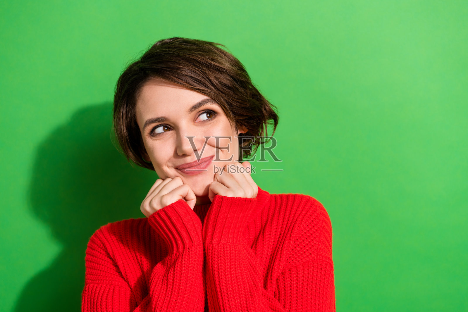 乐观漂亮的黑发女士的照片看起来空旷穿红色毛衣孤立在明亮的绿色背景照片摄影图片