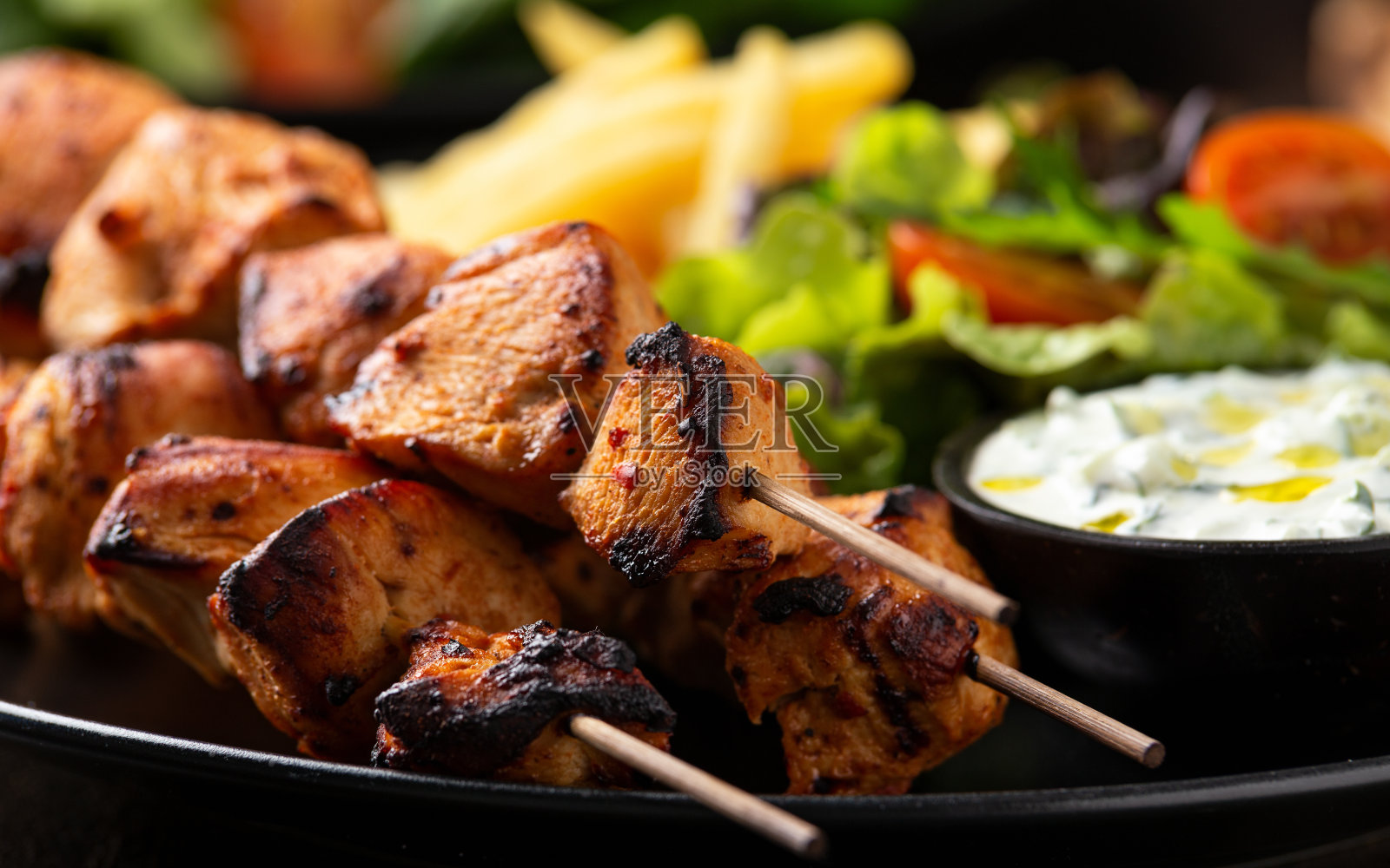 鸡柳串，烤肉串配土豆片，沙拉和新鲜的自制酸奶黄瓜照片摄影图片