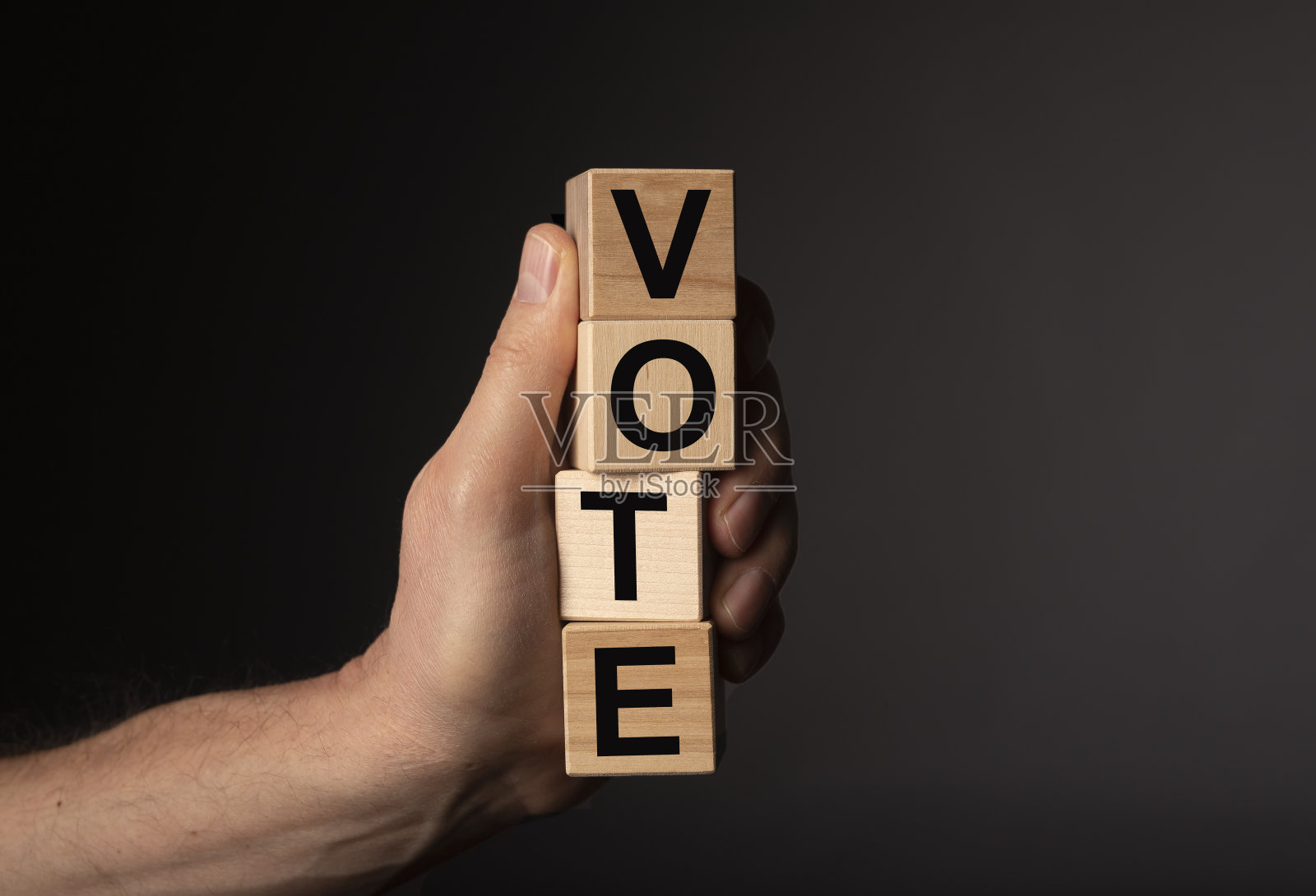 投票字木方在男性手中超过深色背景与拷贝空间照片摄影图片