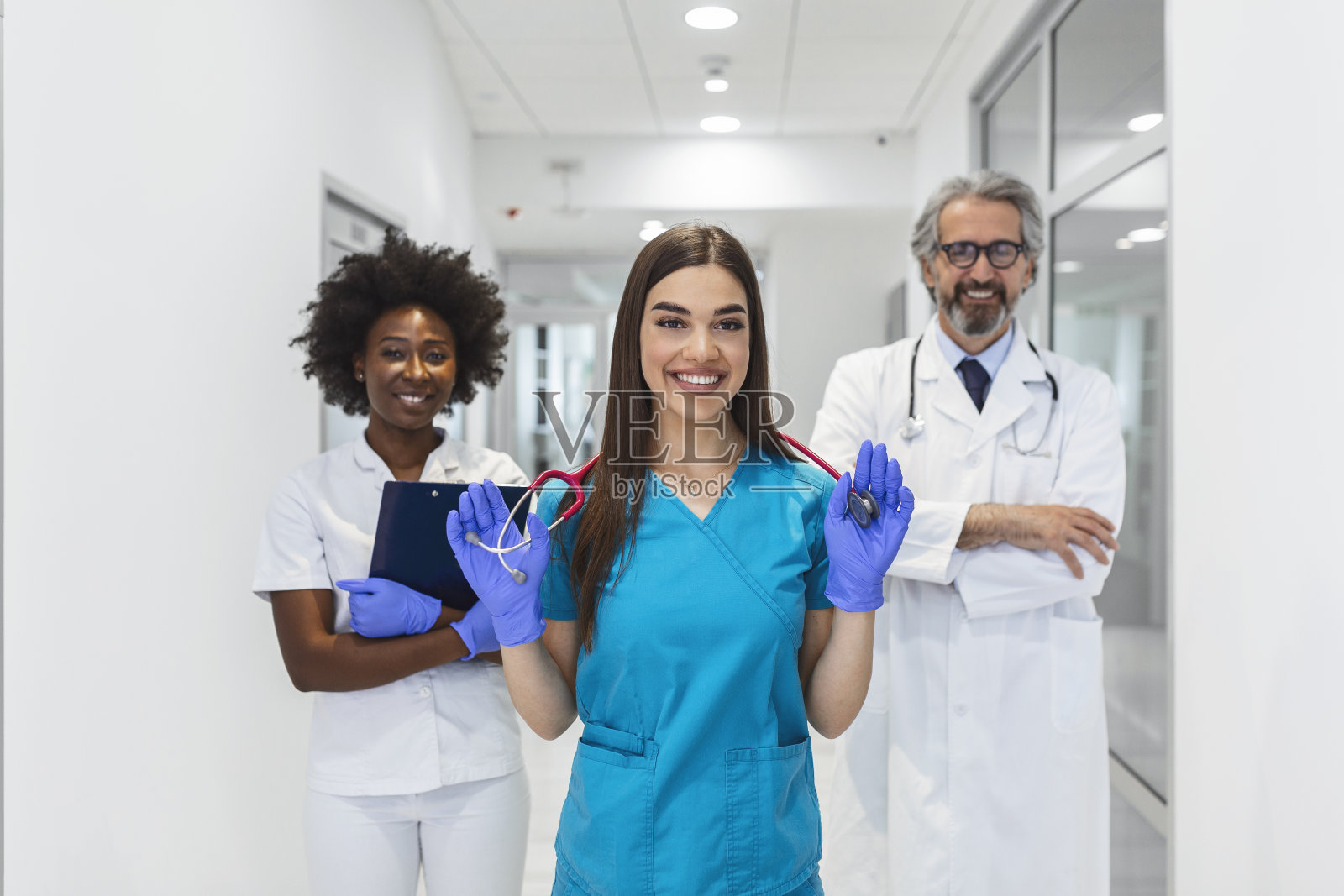 国际医生团队。医院的医务人员。混合种族非洲和高加索医生和护士会议。临床人员戴口罩和听诊器。冠状病毒的爆发。照片摄影图片