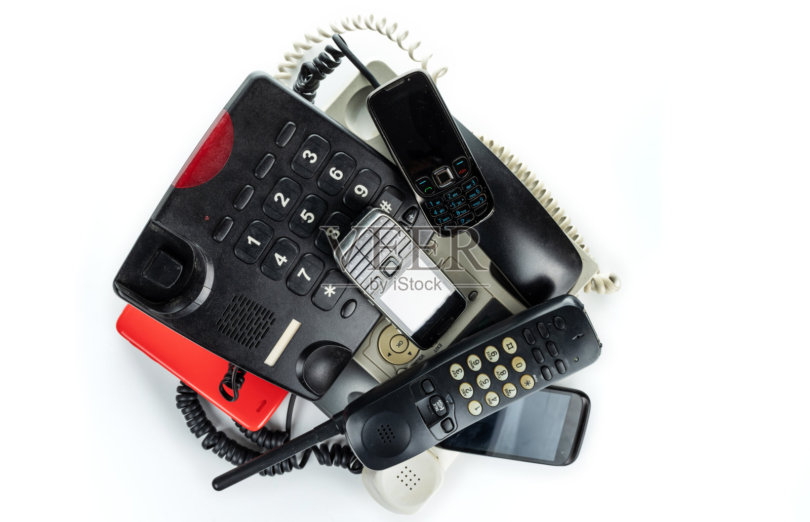 旧的台式电话、无绳电话、手机和智能手机堆在一起照片摄影图片