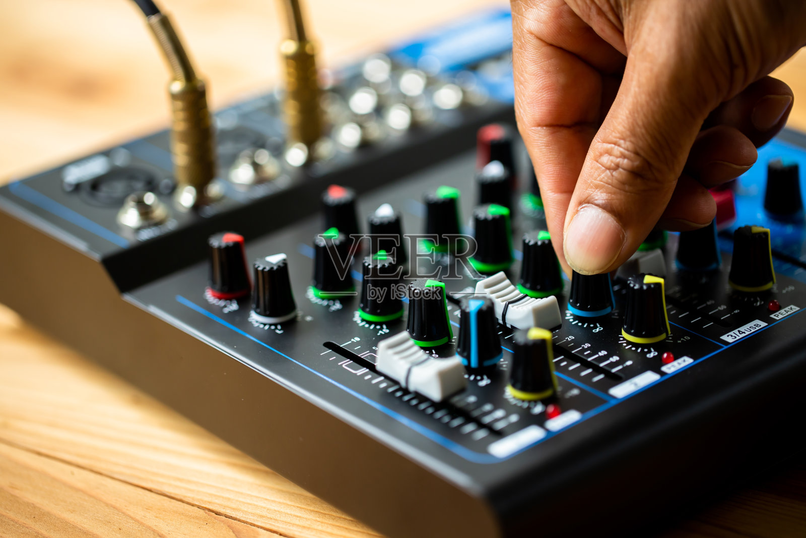 选择焦点声音电子混音器和均衡器与手转动和调整按钮和滑动音量。照片摄影图片