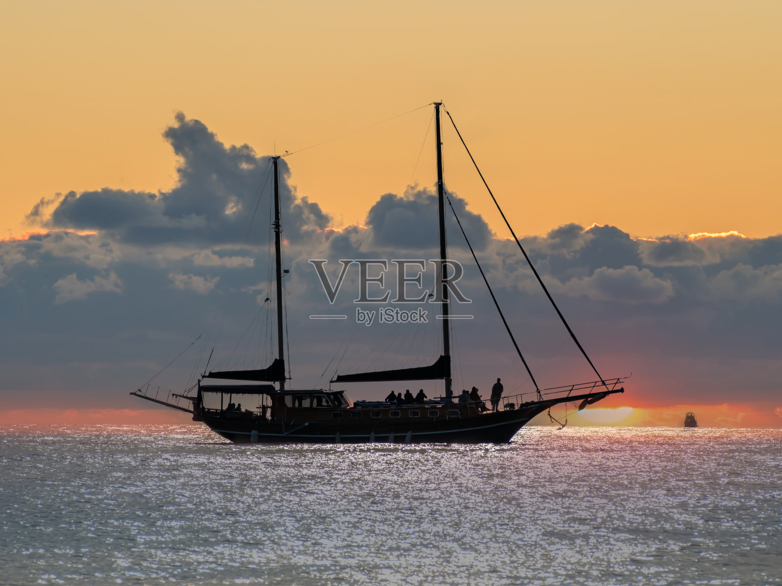 双桅经典帆船在多云的日落。照片摄影图片