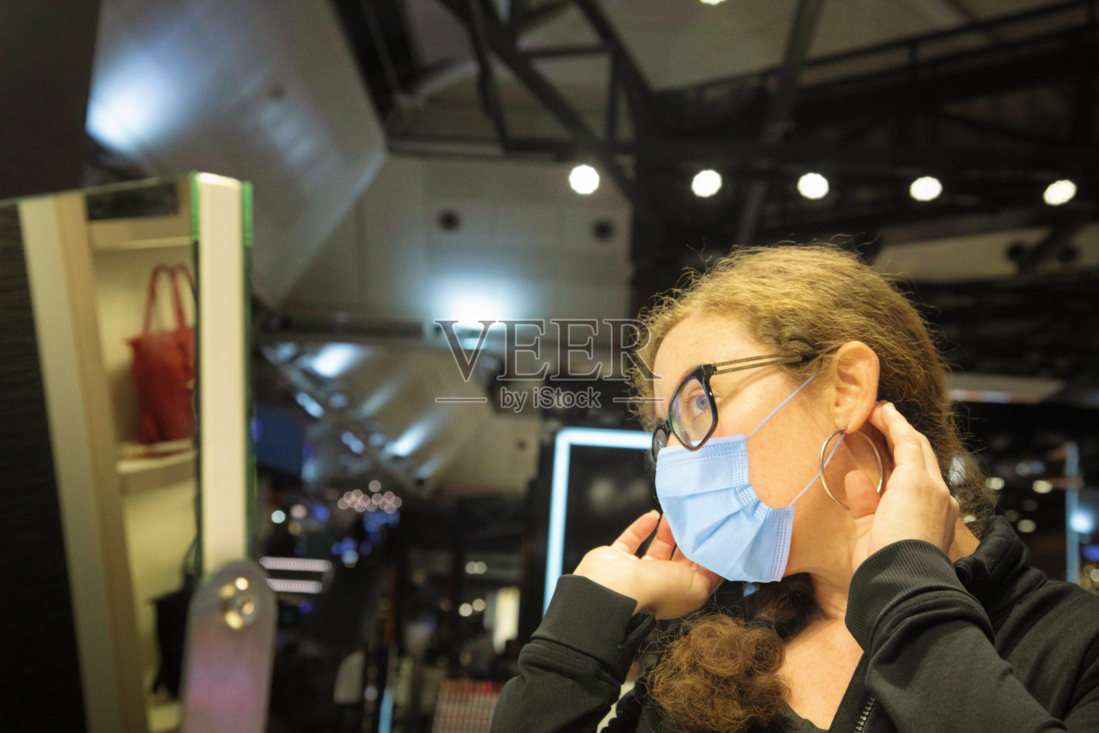 女性在机场戴着防护面具试眼镜照片摄影图片