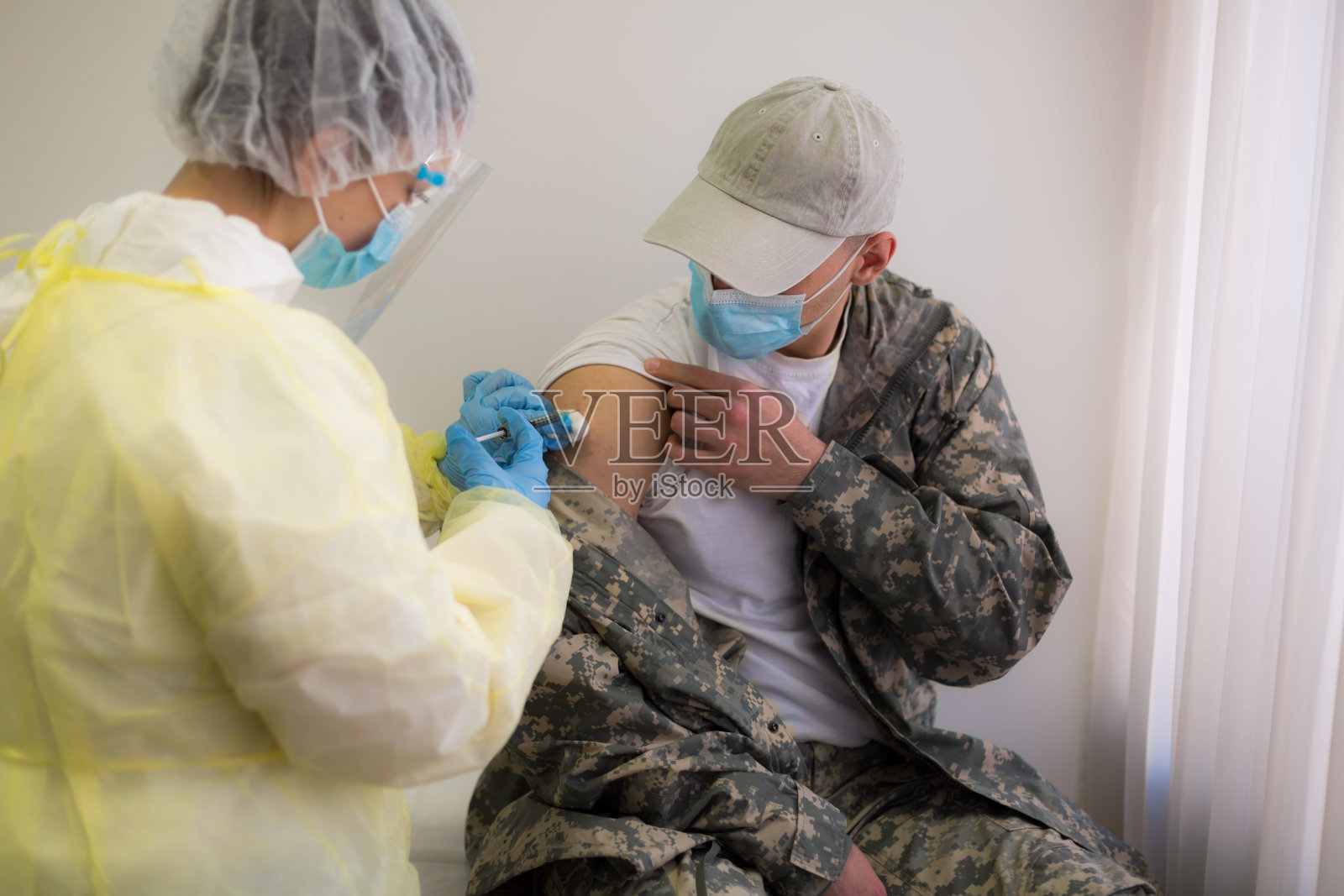 一名身穿军装的年轻人接种covid-19疫苗照片摄影图片