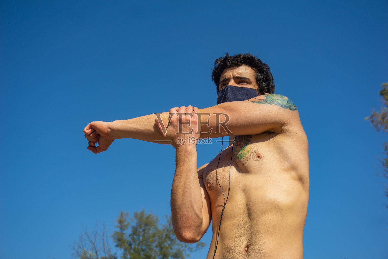 赤膊男子带着口罩伸展身体，锻炼身体照片摄影图片