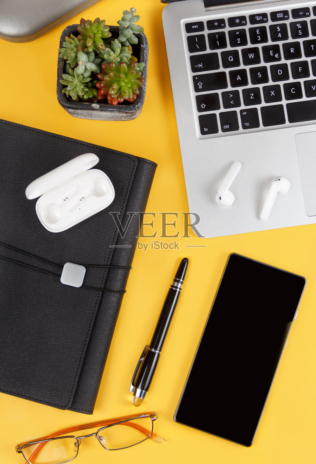 手机和现代小玩意在黄色背景上俯视图照片摄影图片