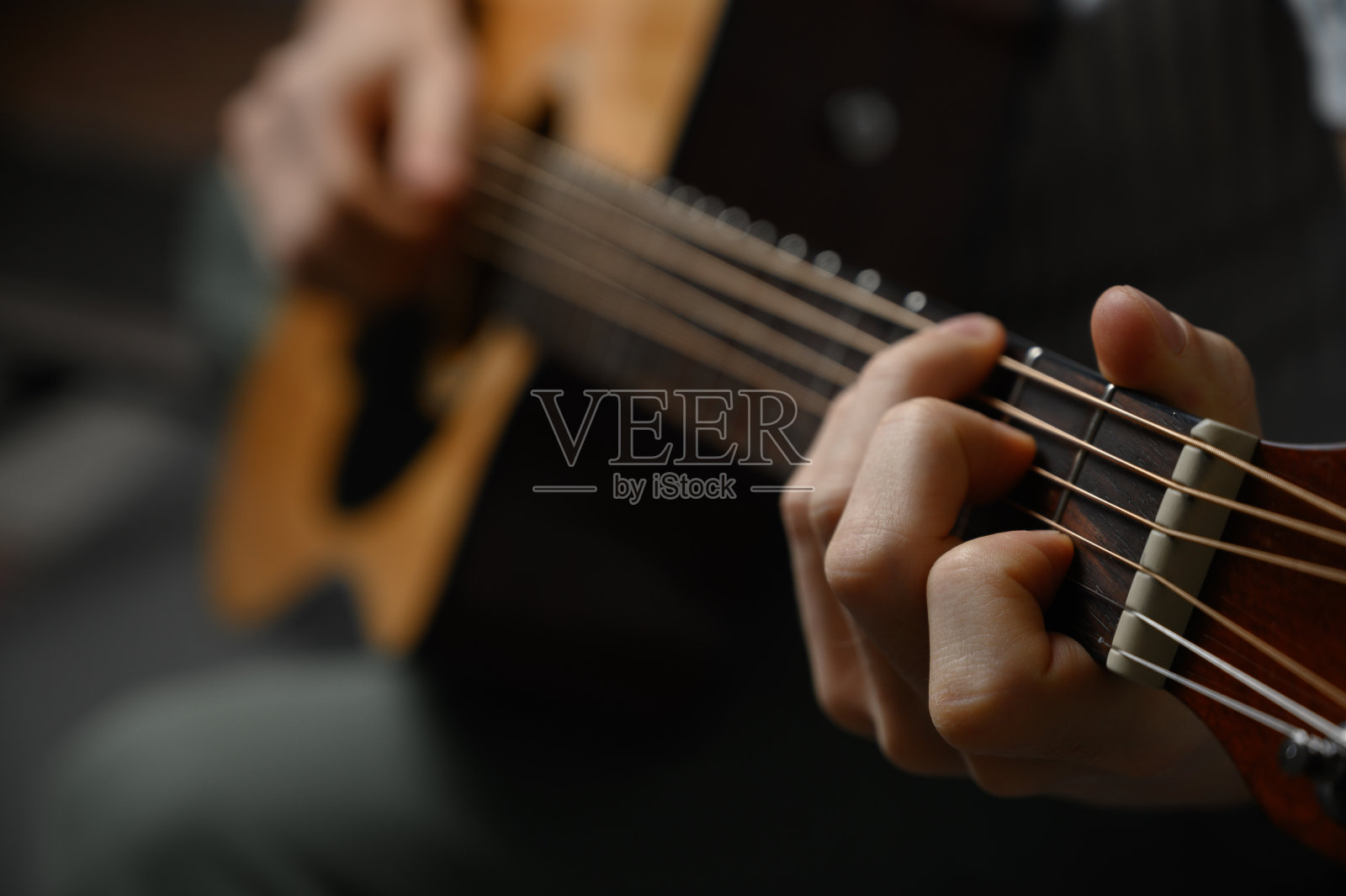 一个弹吉他的男人，掩护在线课程，在家学习。照片摄影图片