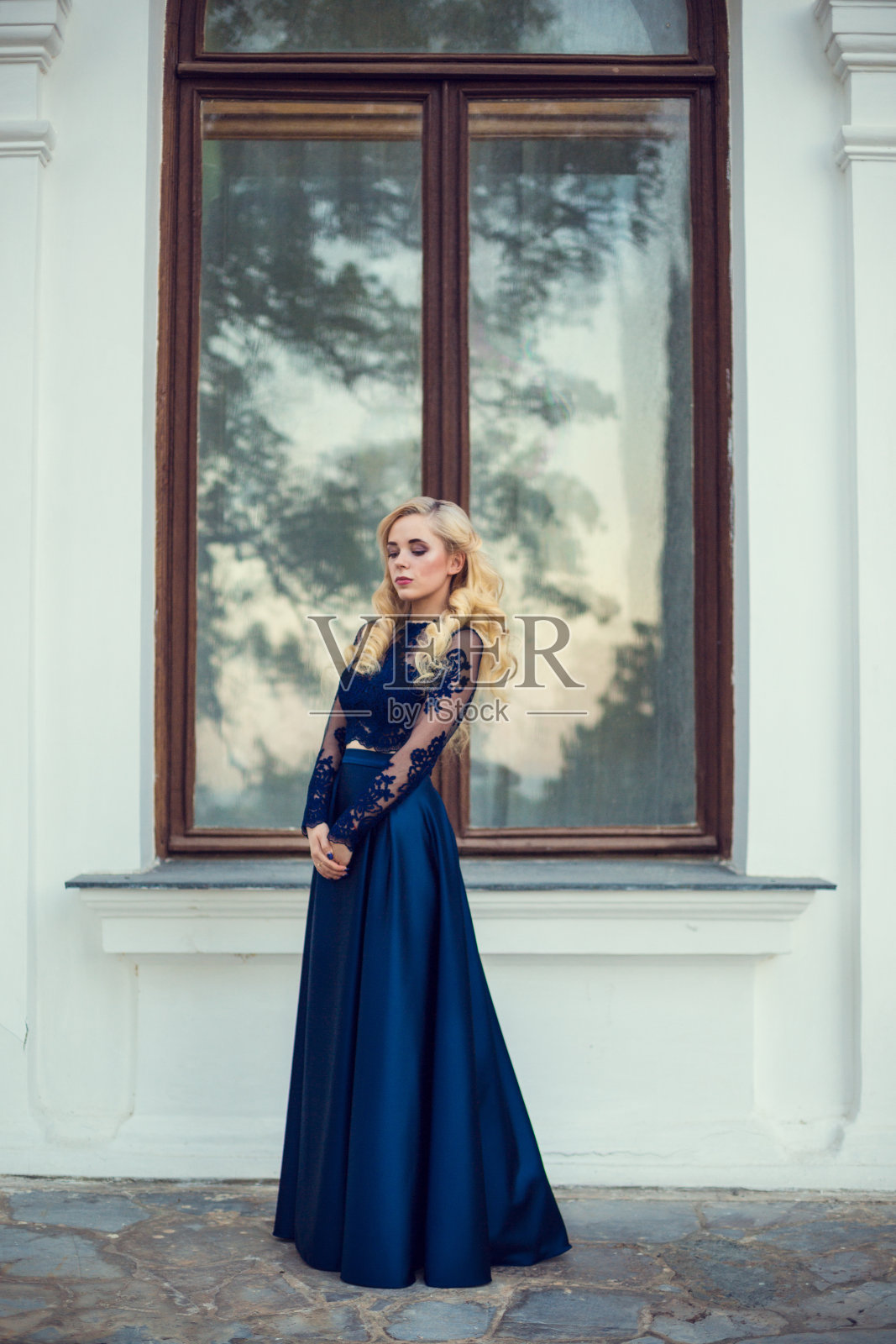 时尚的头发凌乱的辫子周围的头。快乐美丽的年轻模特女孩在夏天盛开的公园。照片摄影图片