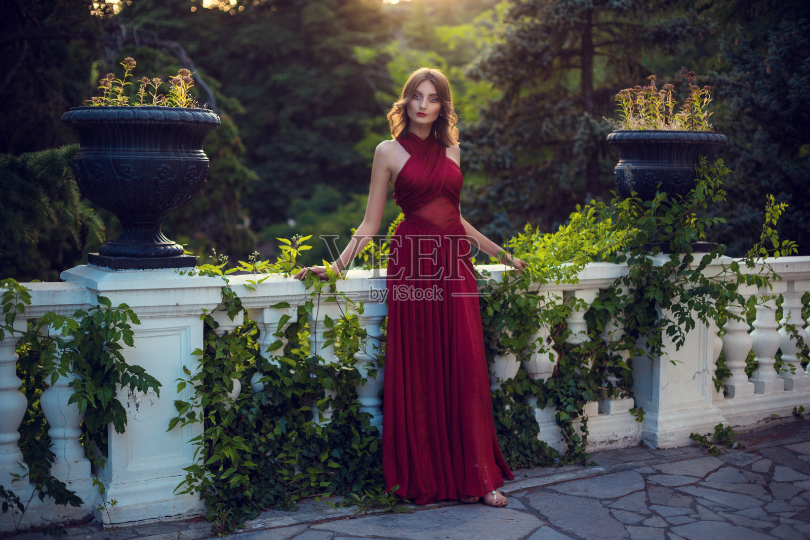 时尚的头发凌乱的辫子周围的头。快乐美丽的年轻模特女孩在夏天盛开的公园。照片摄影图片