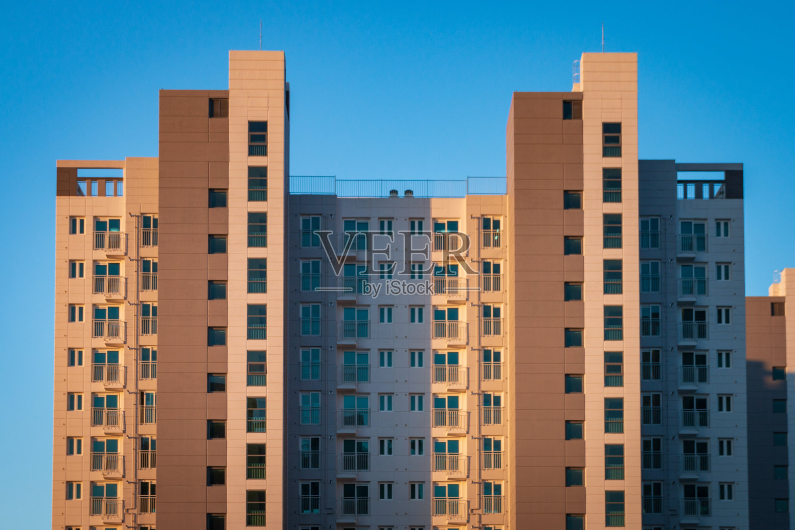 蓝色天空前的公寓大楼照片摄影图片