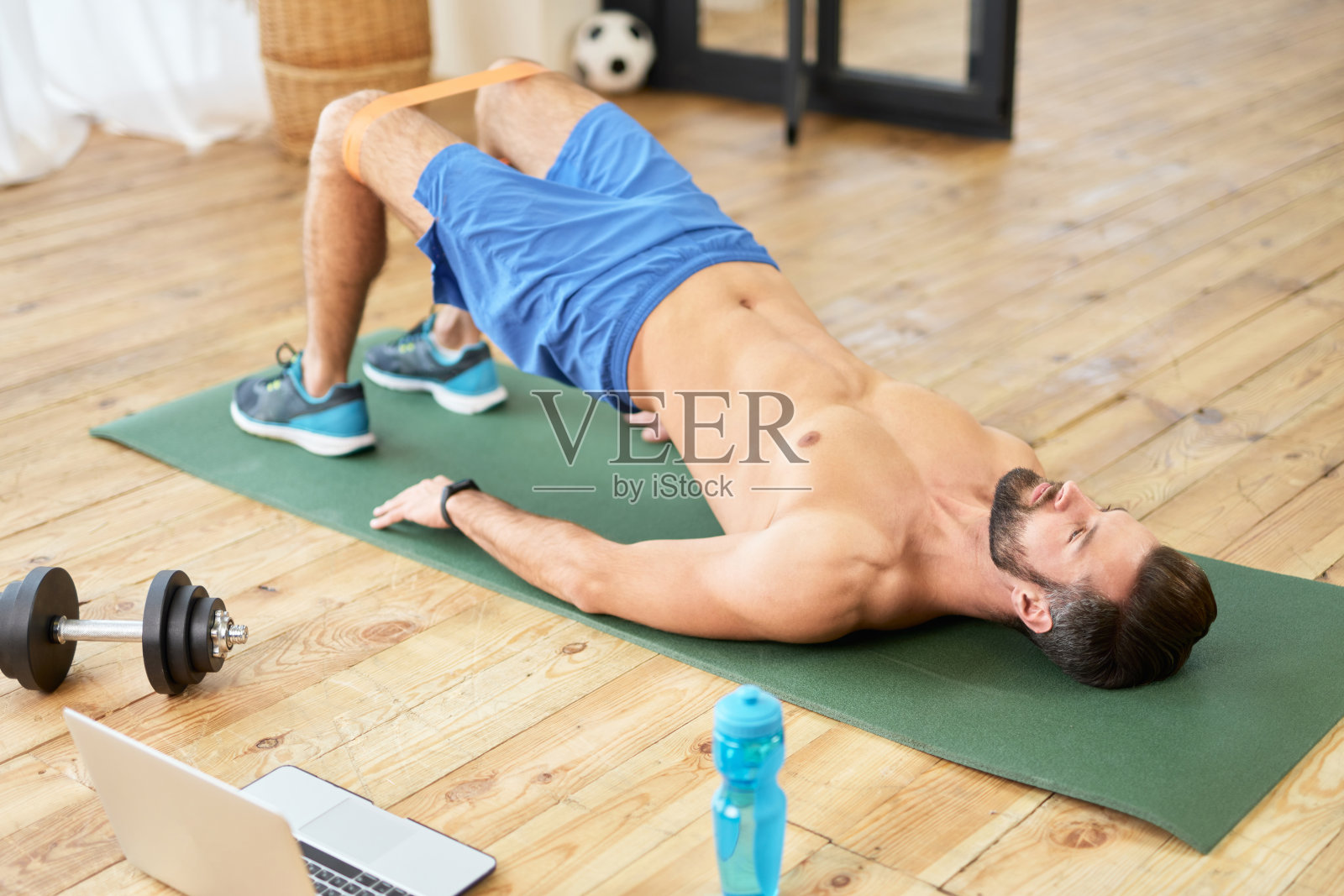 赤膊运动员在家里做腹肌锻炼照片摄影图片