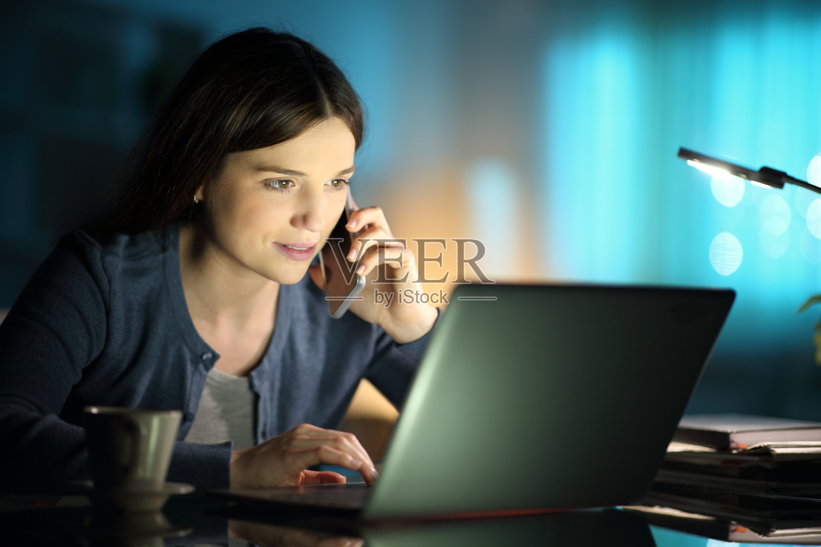 一个晚上在家用笔记本电脑打电话的女人照片摄影图片