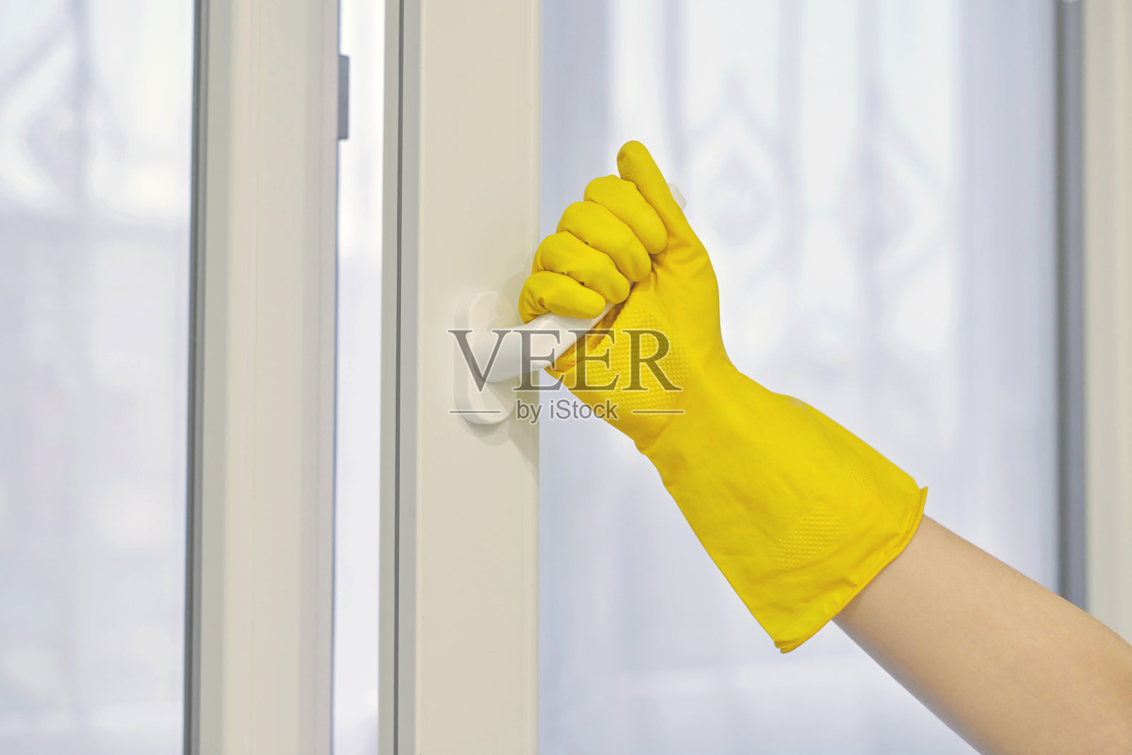 手戴防护手套开、关窗户。照片摄影图片