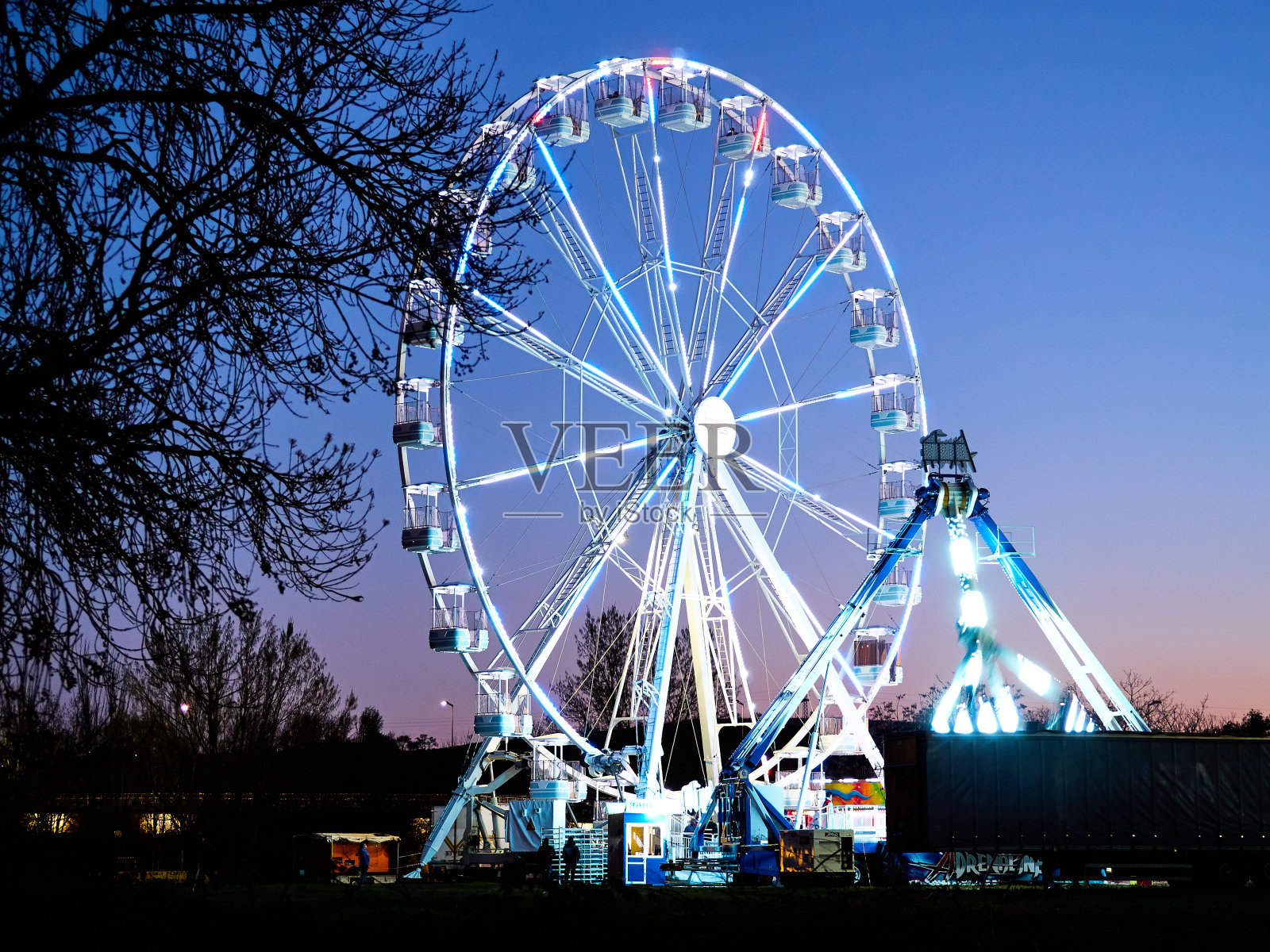 傍晚，在摩天轮和游乐园。照片摄影图片