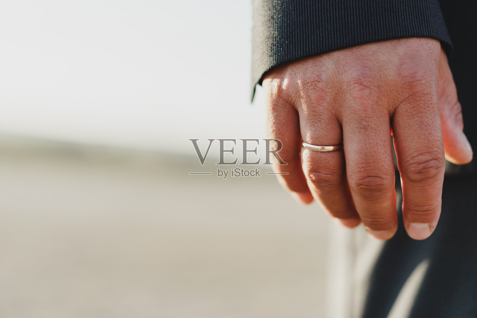 新郎的手戴着金戒指照片摄影图片