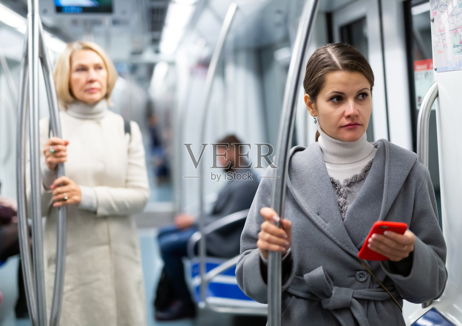 年轻女子在地铁里拿着手机照片摄影图片