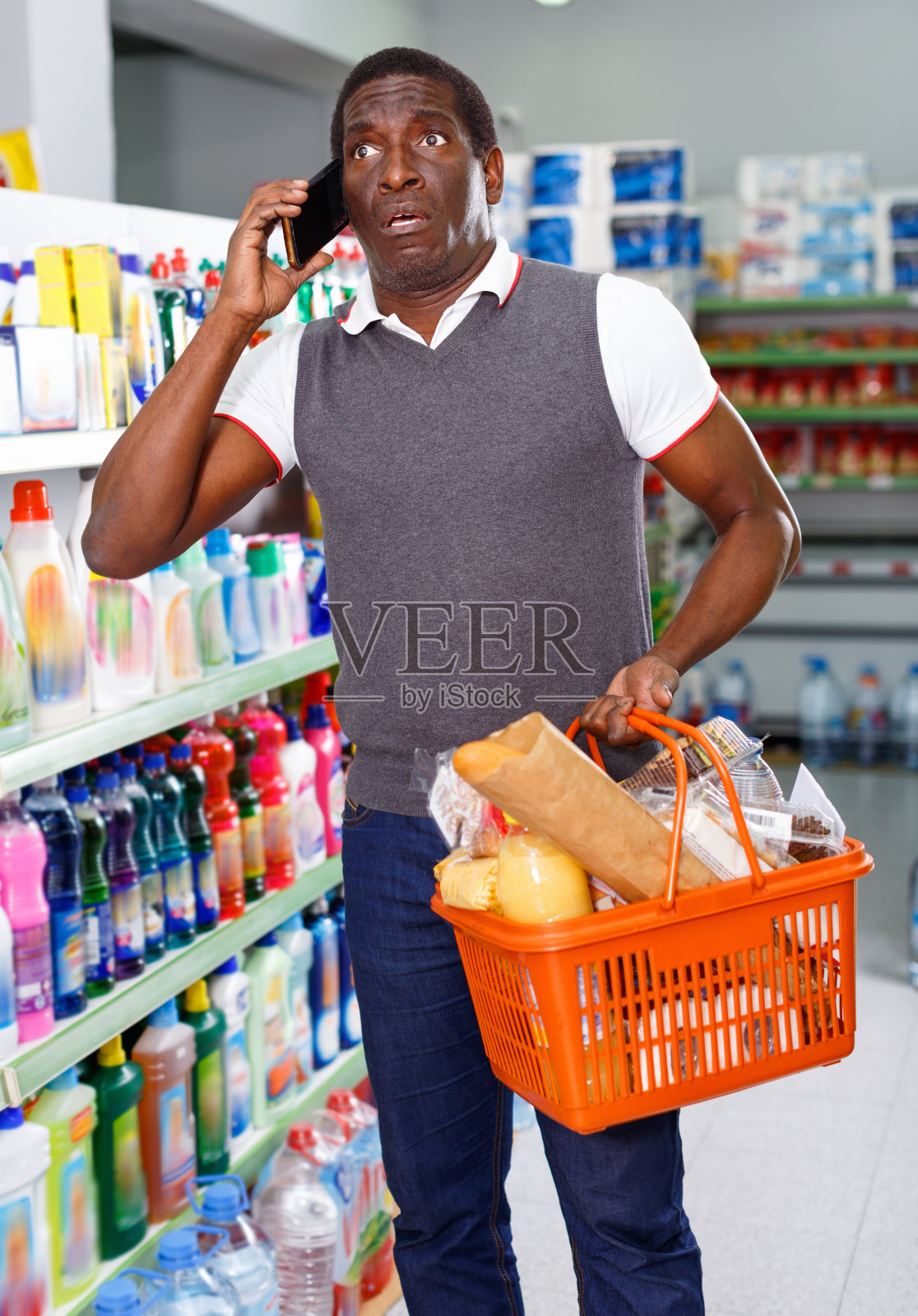 积极的非洲裔男子在超市购物时使用智能手机照片摄影图片