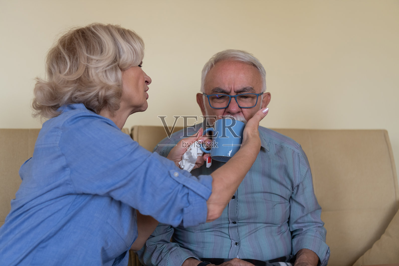 一位老人因看护者在他身边而感到高兴。一位患流感的老人正在接受他的大老婆的治疗。照片摄影图片