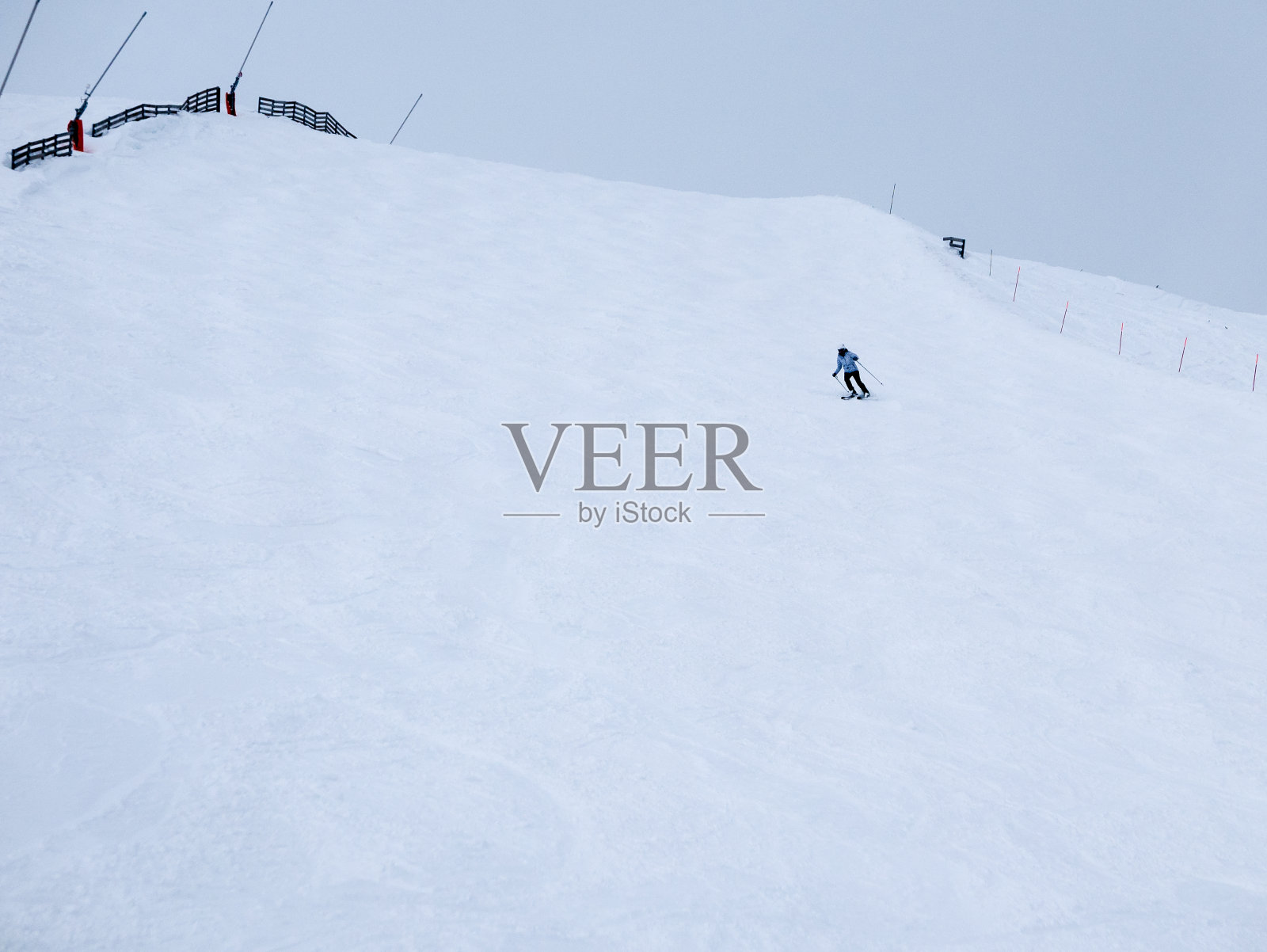 视野雪山边与小独自滑雪者在远处。照片摄影图片