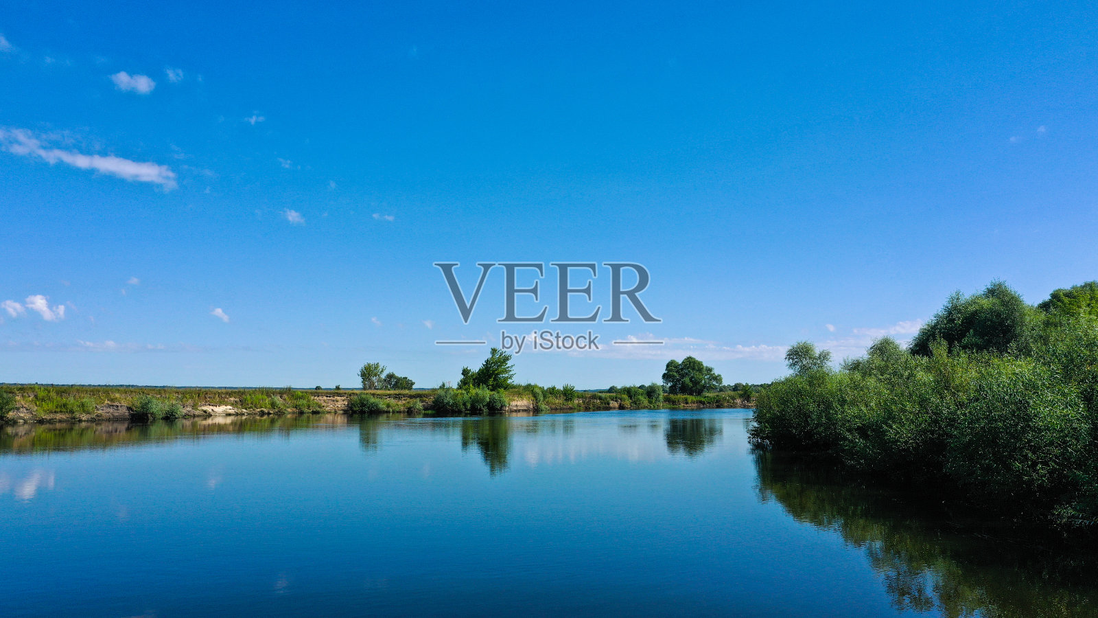 鸟瞰图，一个美丽的夏季景观河上，而黎明。俯瞰河与平滑的水面反射蓝色的天空。照片摄影图片