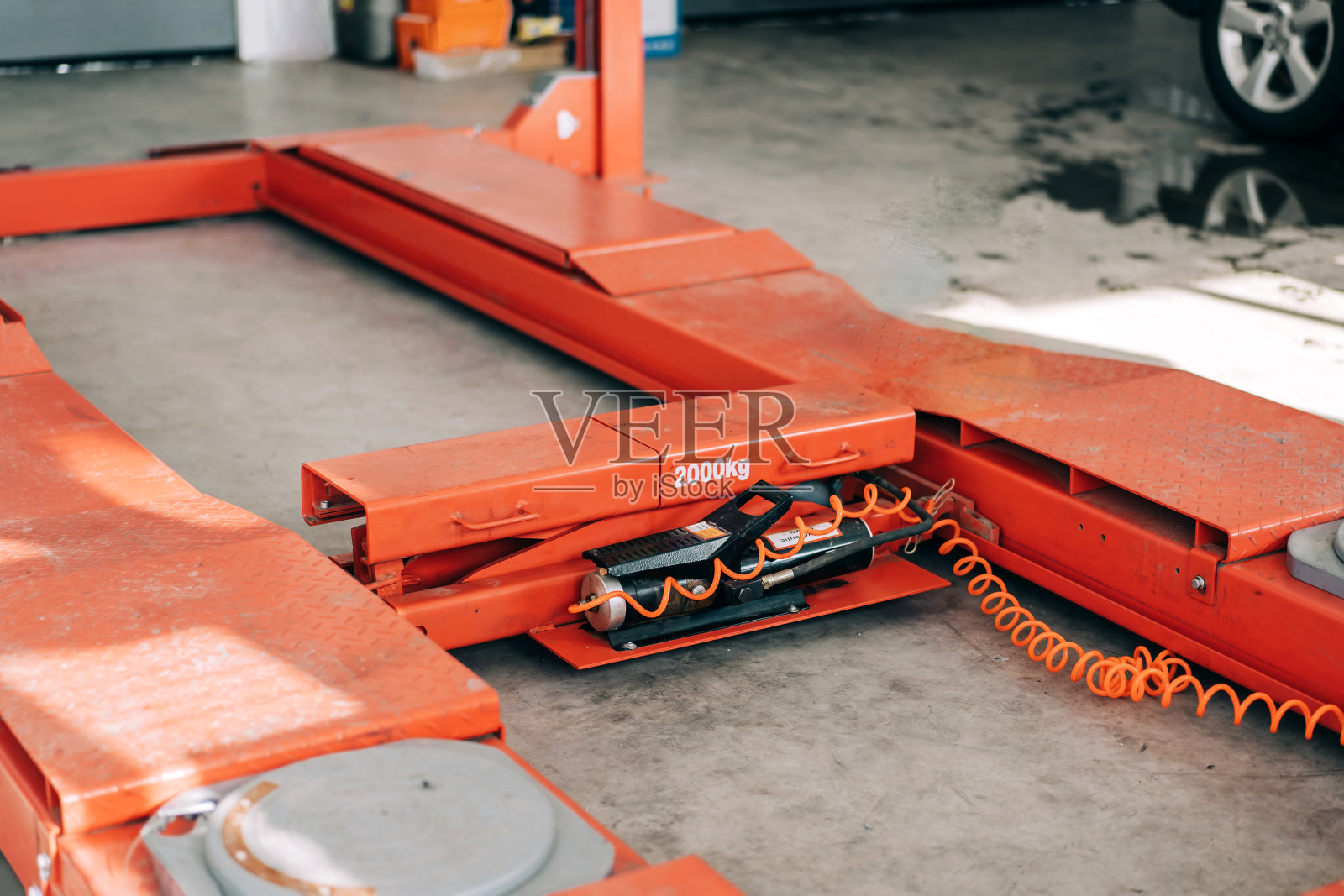 橙色汽车升降机在安静状态下，供室内使用。服务站的起重机械设备照片摄影图片