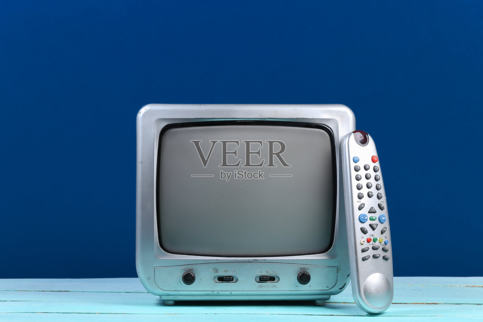 复古电视接收器与电视遥控器在经典的蓝色背景照片摄影图片