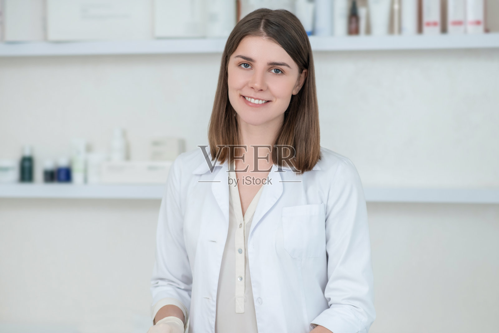 年轻的黑发美容师在工作中看起来很积极照片摄影图片