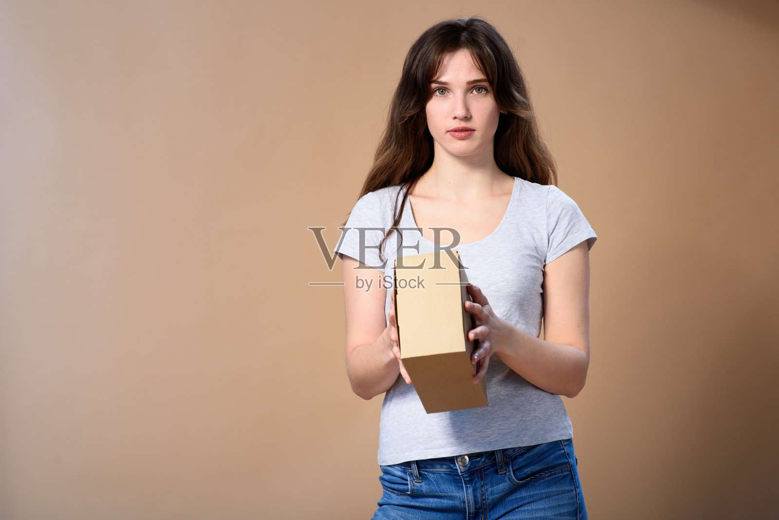 一个披头散发，手里拿着纸盒的女孩照片摄影图片