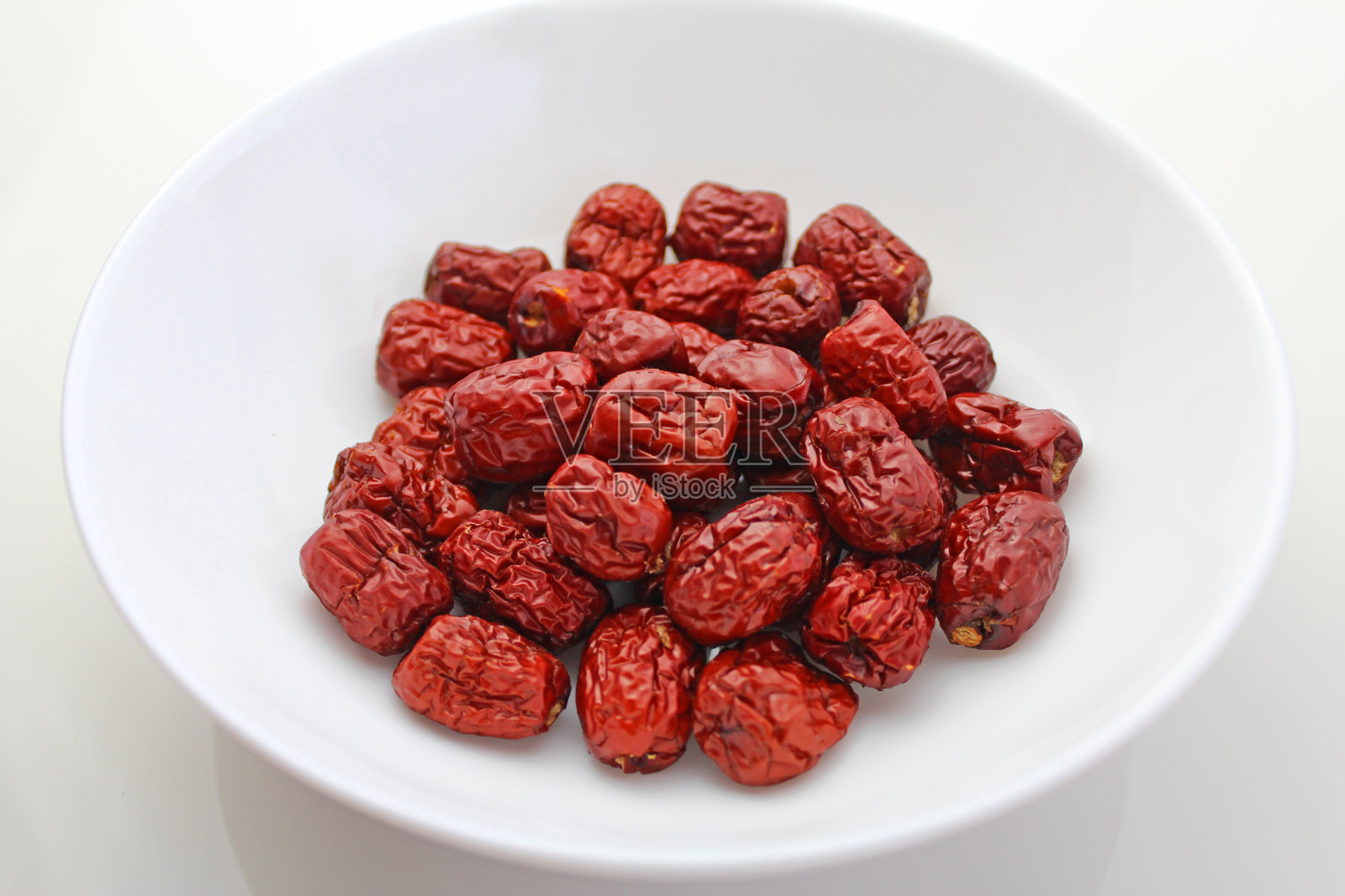 白色背景上的干果红枣。照片摄影图片