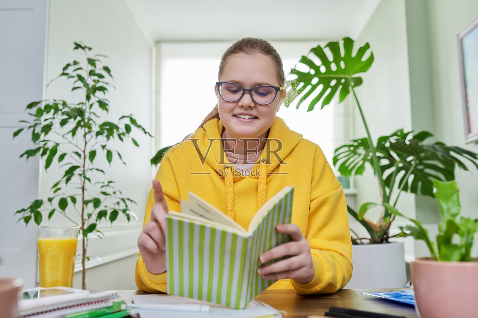 青春期前的女孩在家学习，看着摄像头聊天的女学生照片摄影图片