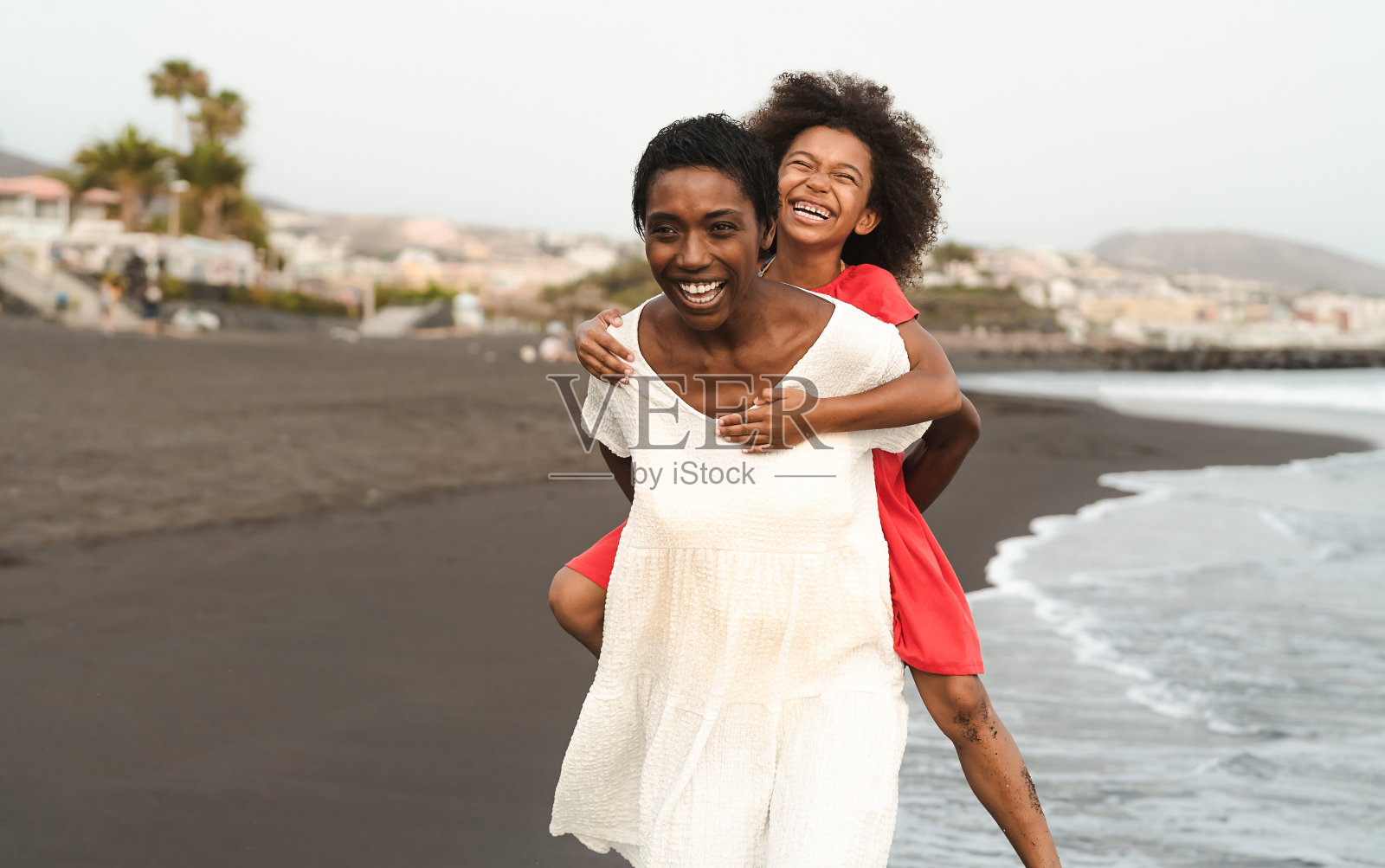 快乐的非洲家庭在海滩上的暑假-非洲裔美国人有乐趣的假期时间-父母爱和旅行的生活方式概念照片摄影图片