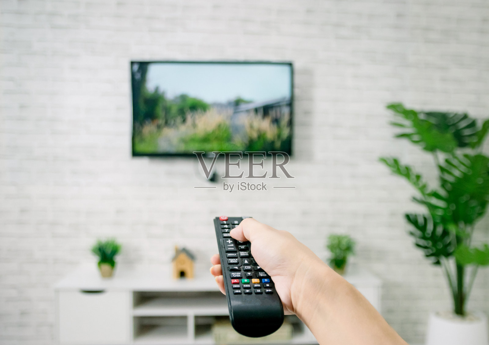 手持客厅电视遥控器照片摄影图片