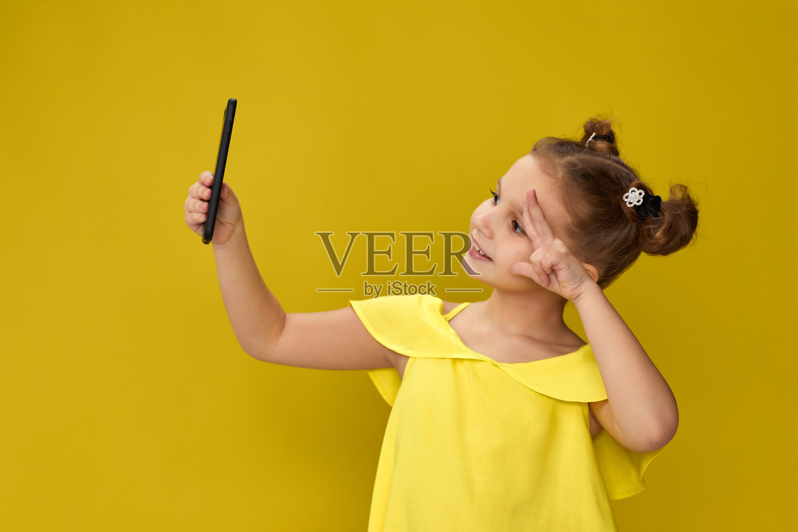 小女孩在智能手机上微笑自拍照片摄影图片