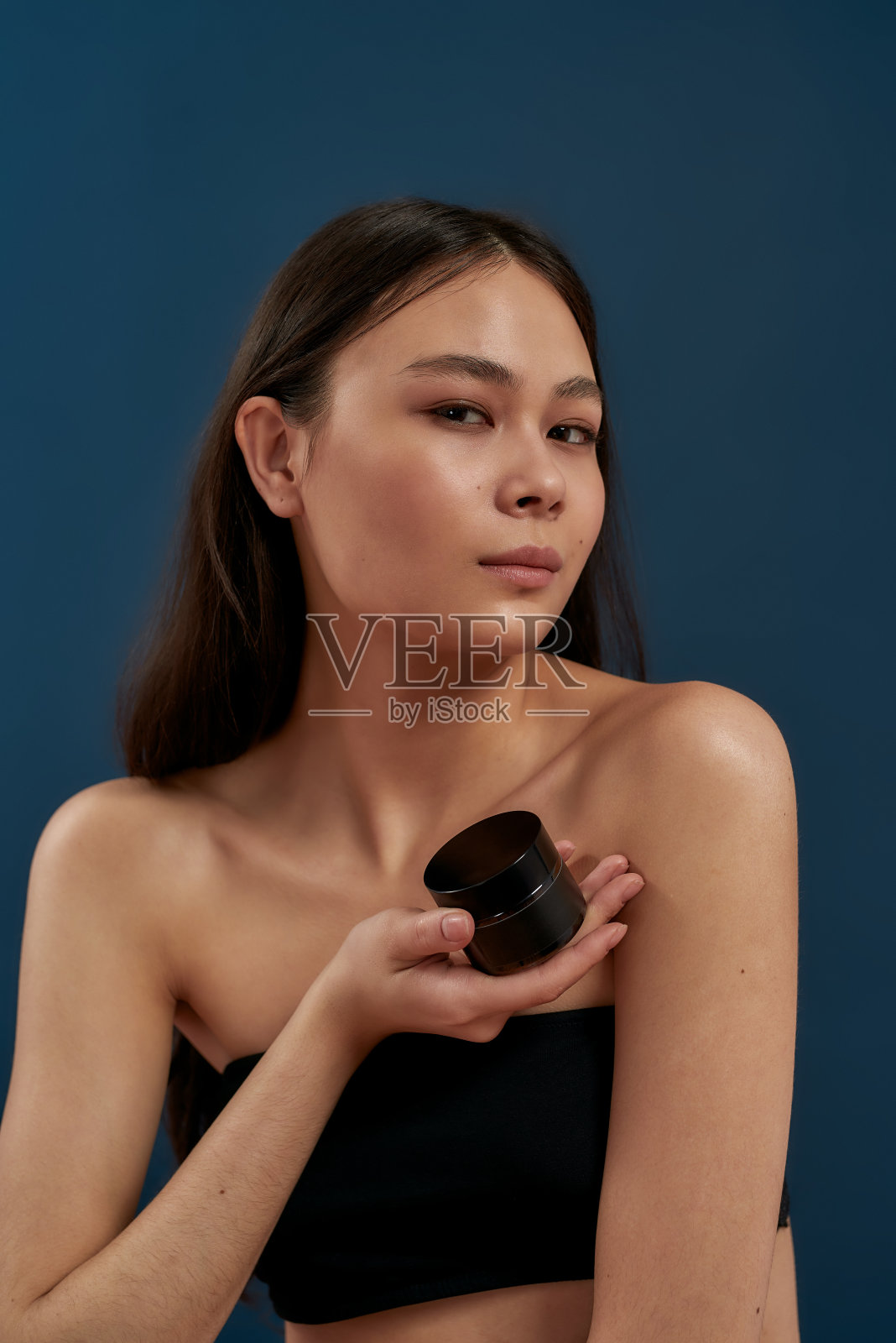 手里拿着护肤霜的漂亮女孩照片摄影图片