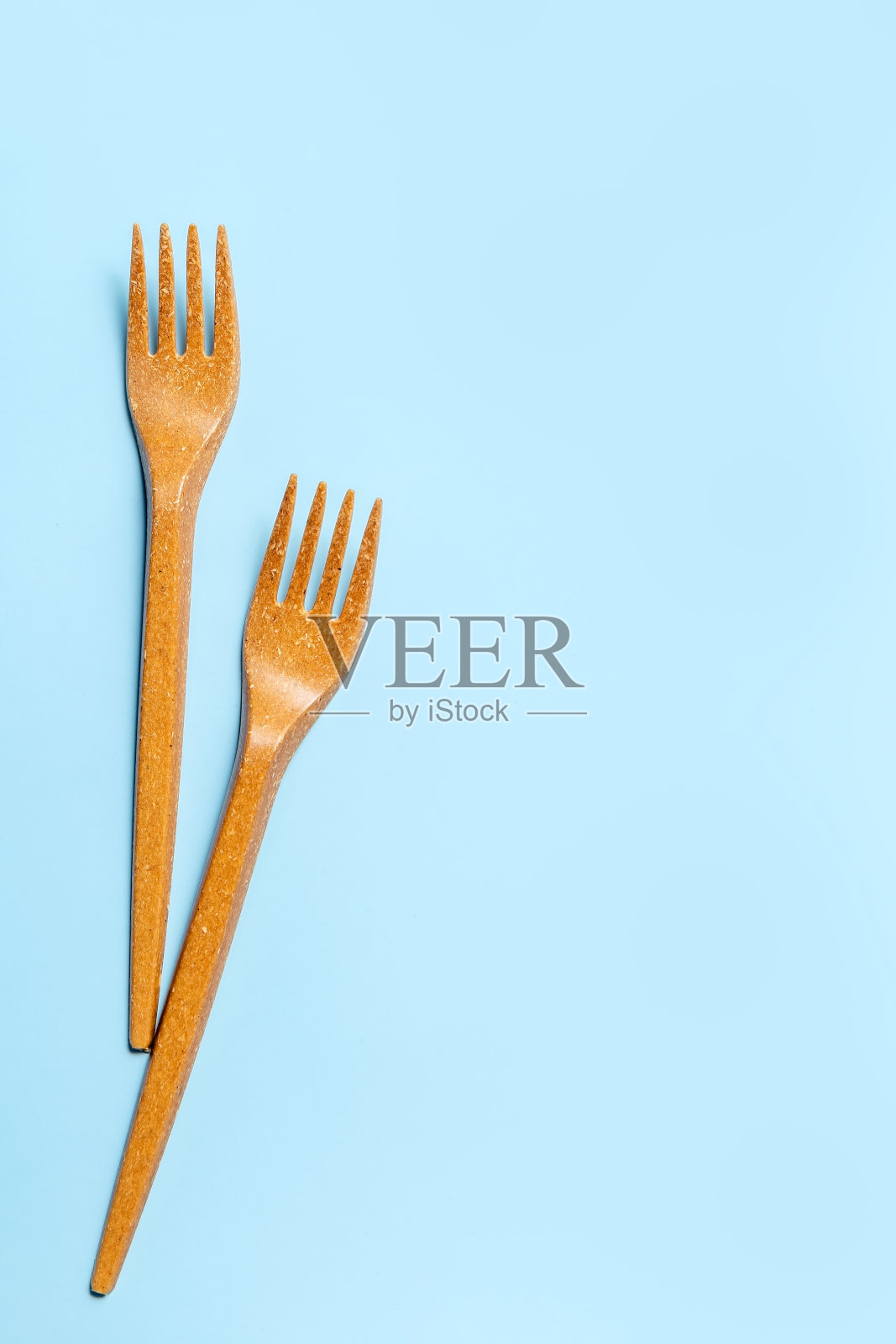 蓝色背景下的一次性塑料叉子。一次性餐具。的概念。副本的空间。照片摄影图片