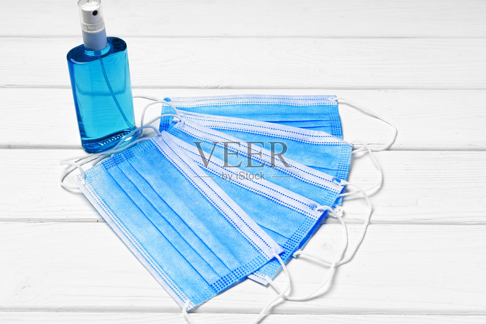 医用口罩和消毒液凝胶在白色木质背景上照片摄影图片