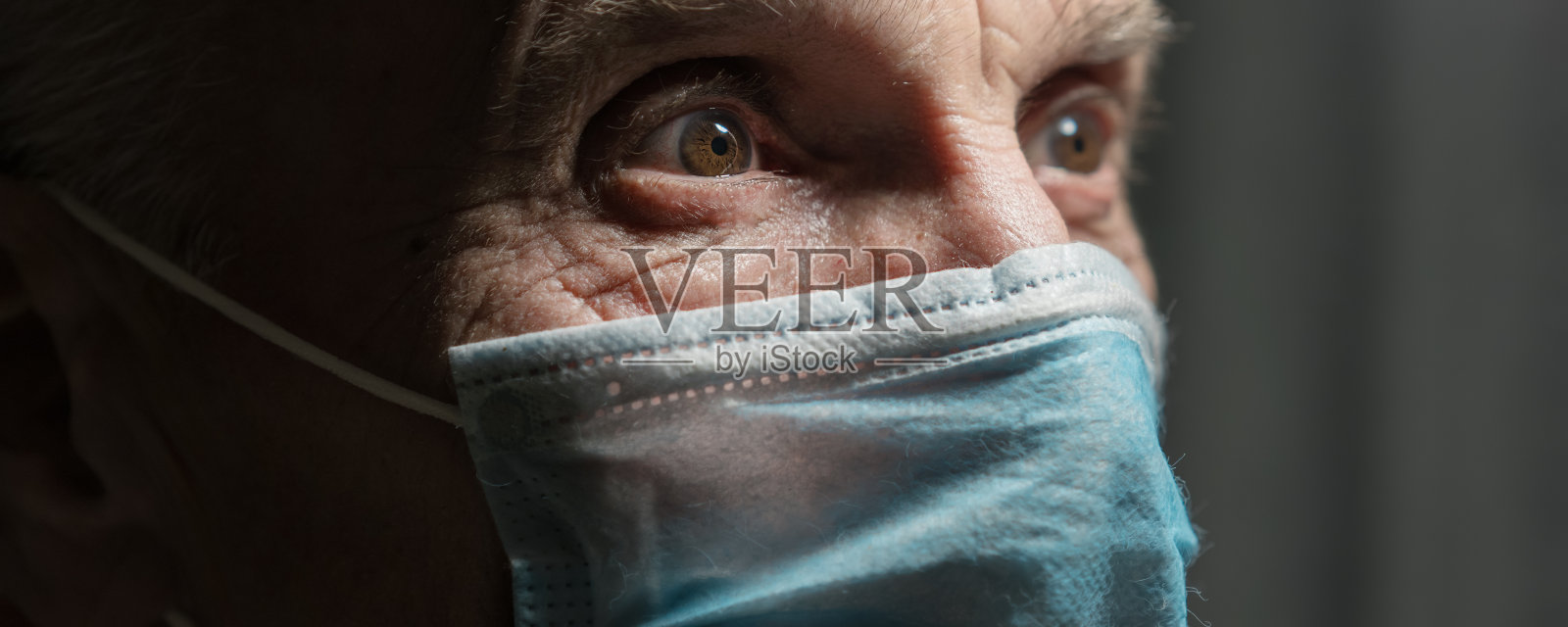 在黑暗的护理室里戴面具的老人的大规模肖像照片摄影图片