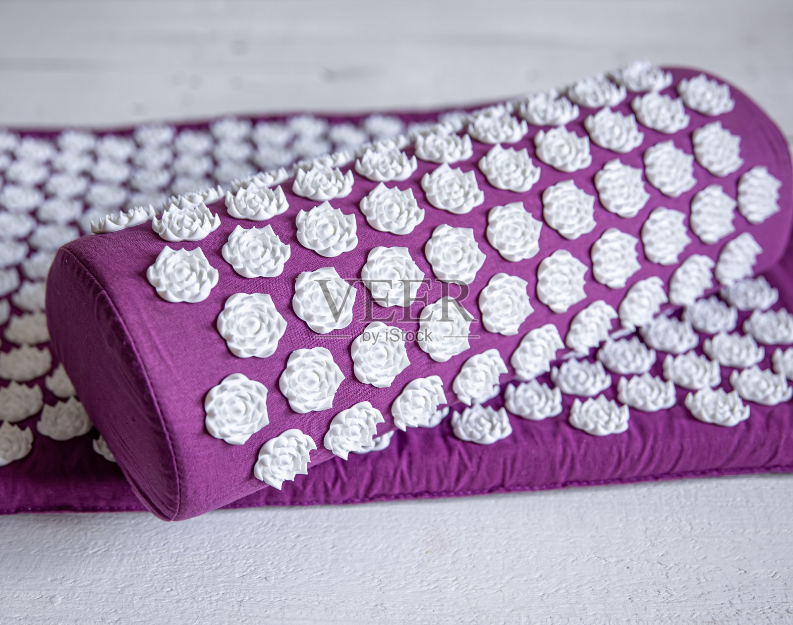 按摩针灸垫，配有枕头和白色按摩头。照片摄影图片