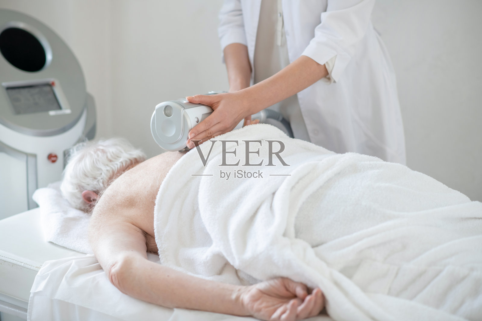 理疗师为一位女性病人做抗骨质疏松治疗照片摄影图片