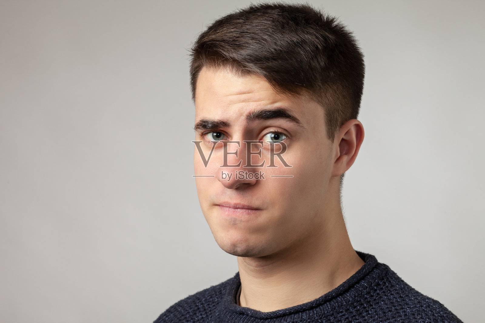 近距离工作室肖像的19岁男子在灰色的背景照片摄影图片