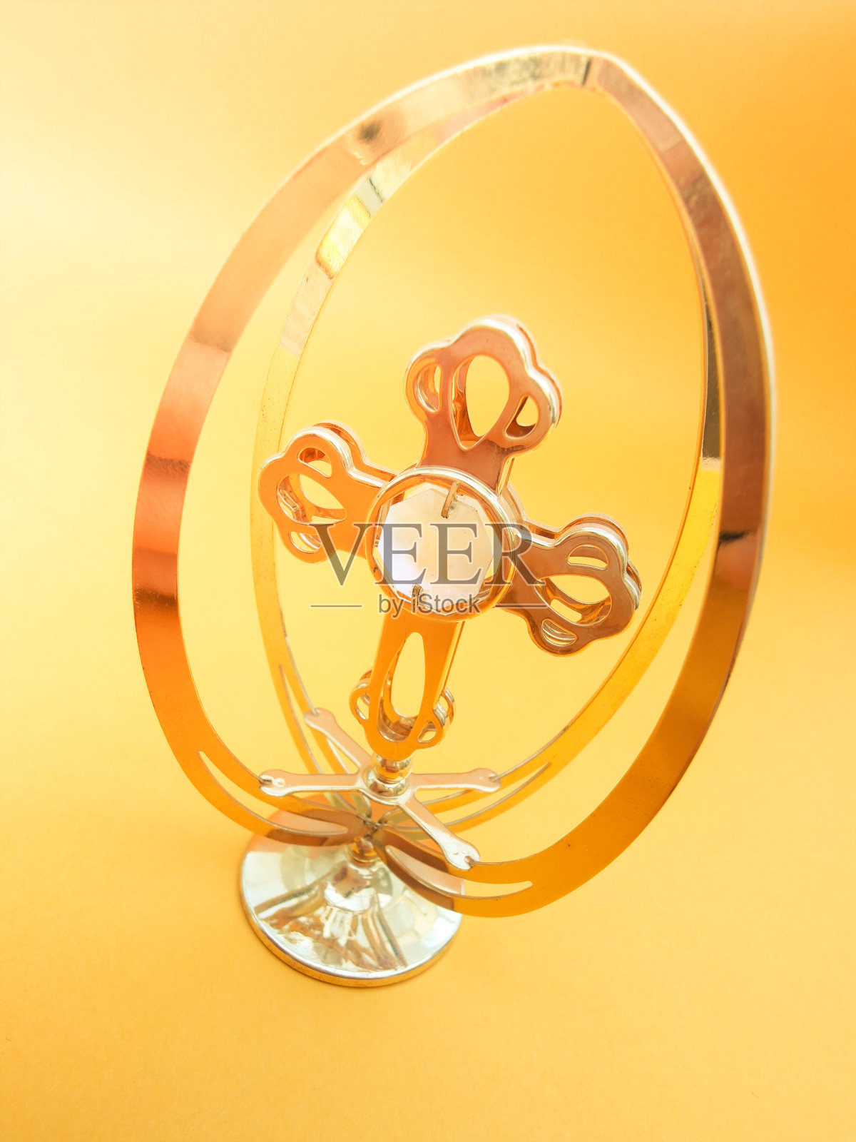 金色金属基督十字架有阴影，孤立在橙色背景上，十字架的宗教象征照片摄影图片