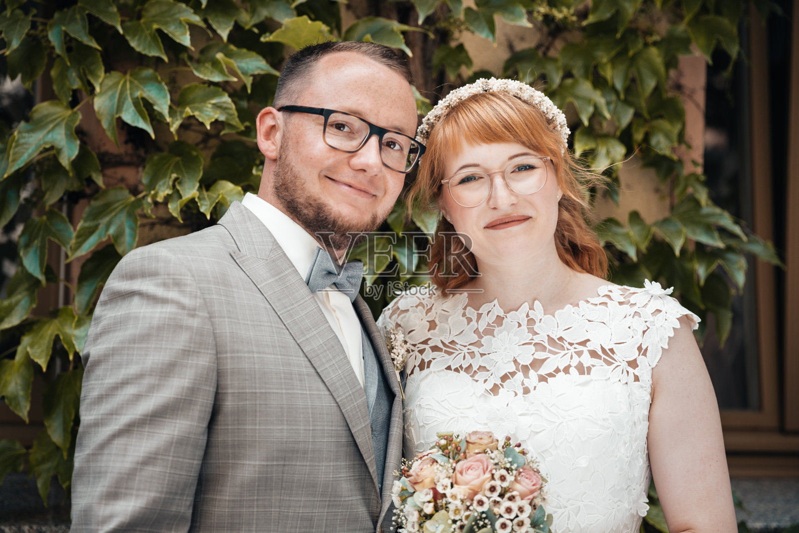 新婚夫妇在绿叶前微笑照片摄影图片