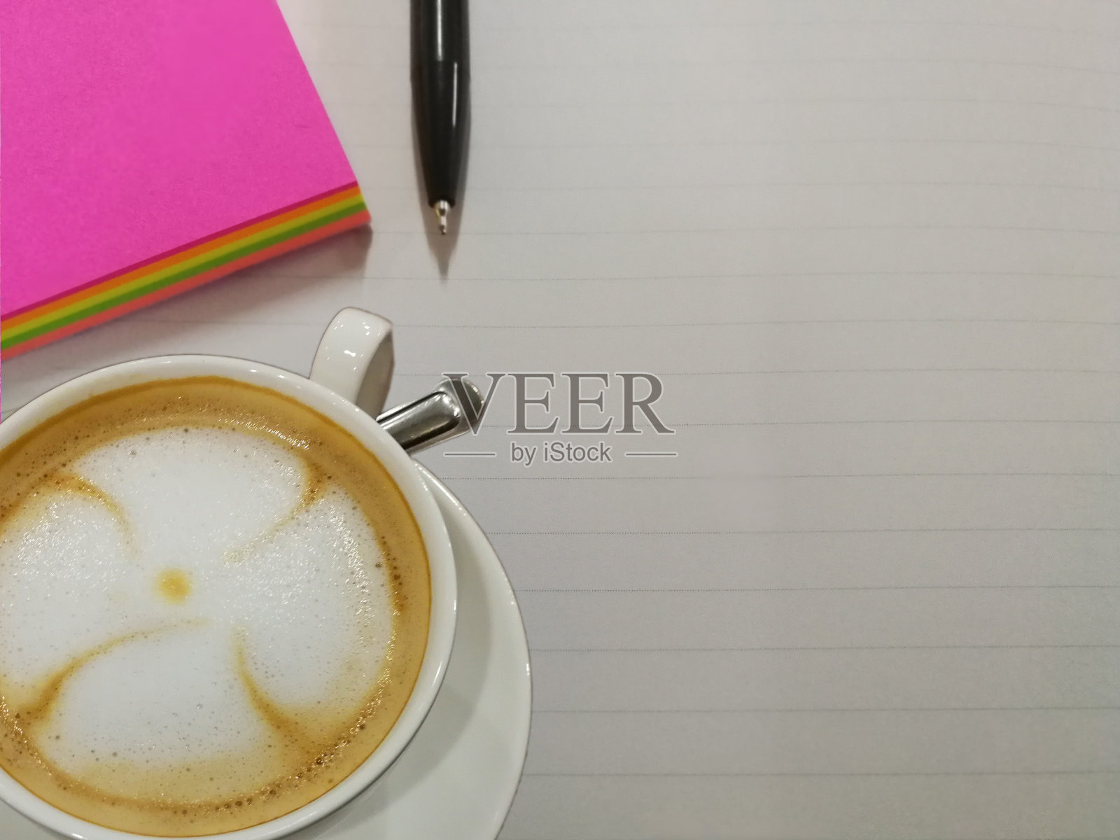 一杯咖啡和一个带笔的便签本照片摄影图片