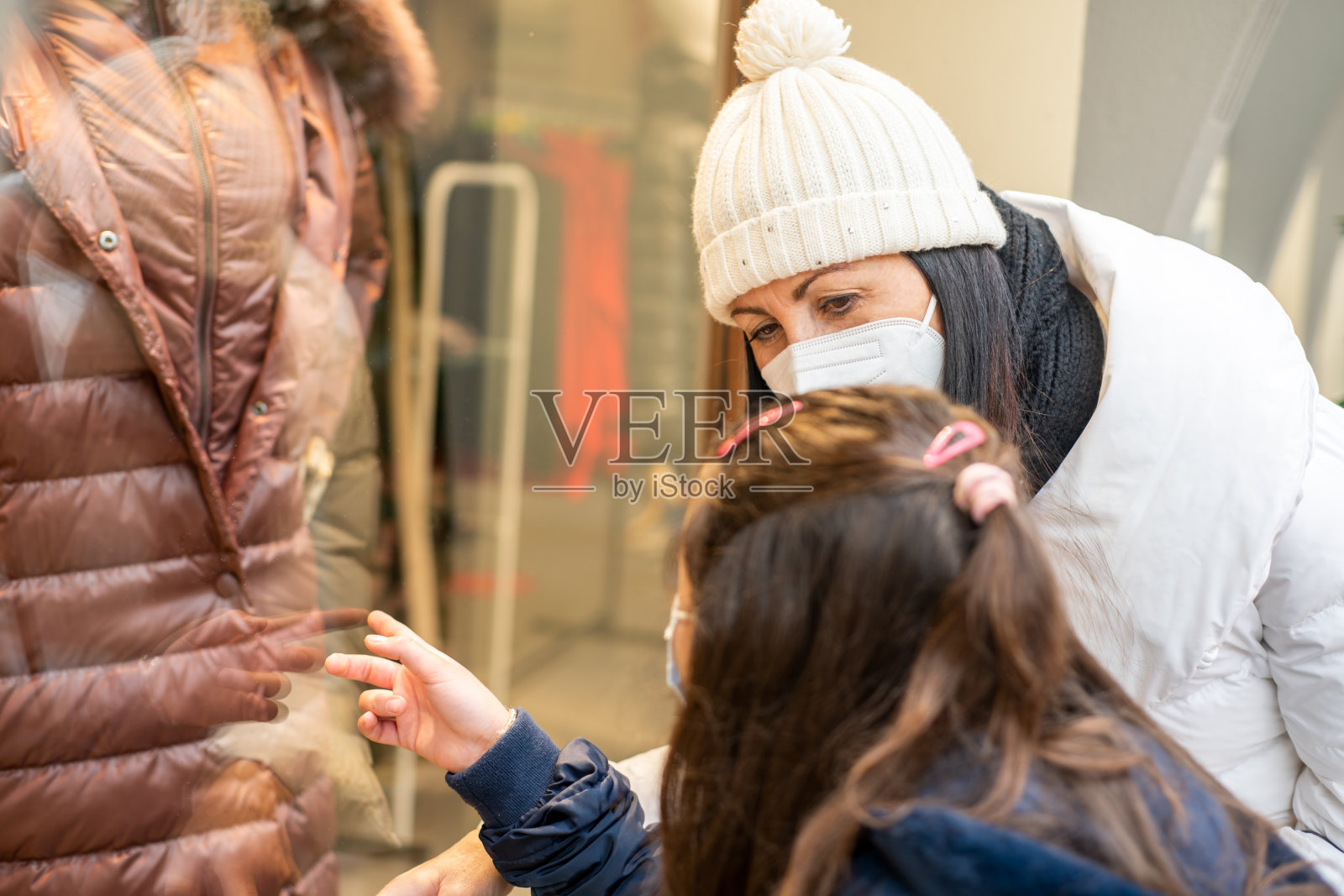 对待自己(购物)。在新冠疫情期间，母女俩戴着防护口罩在超市购物照片摄影图片