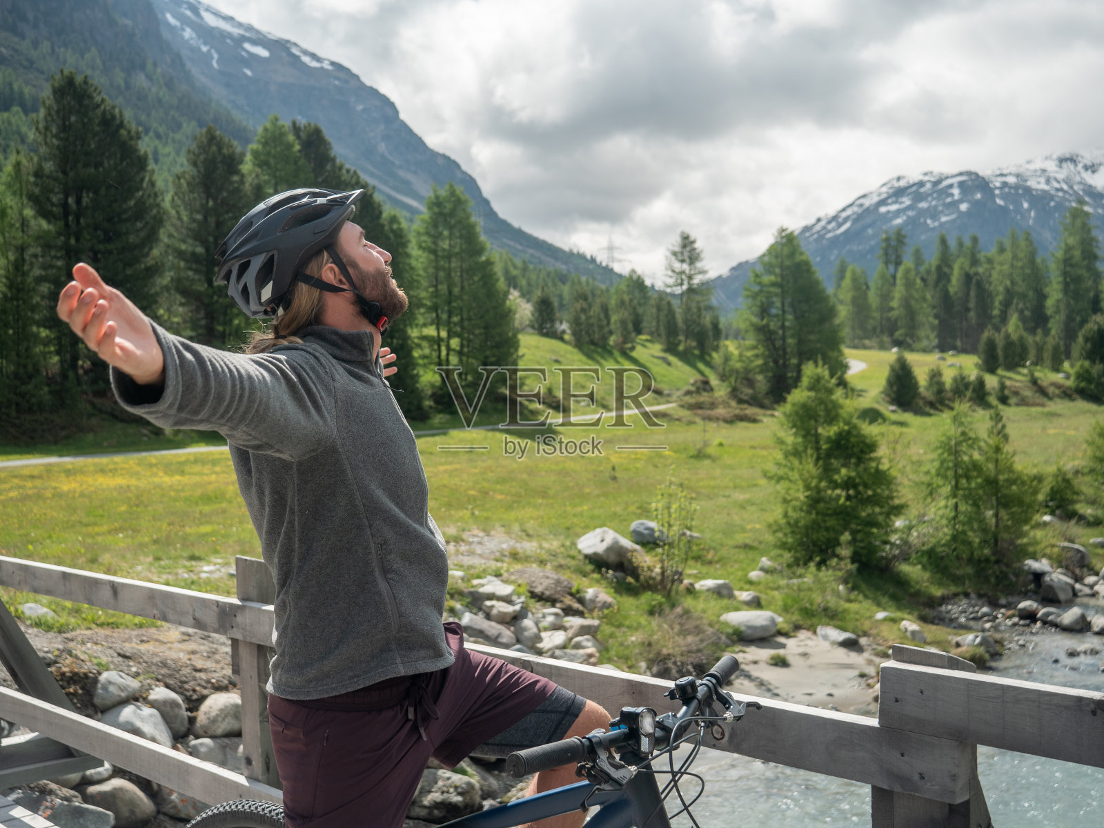山地摩托车手张开双臂享受大自然照片摄影图片