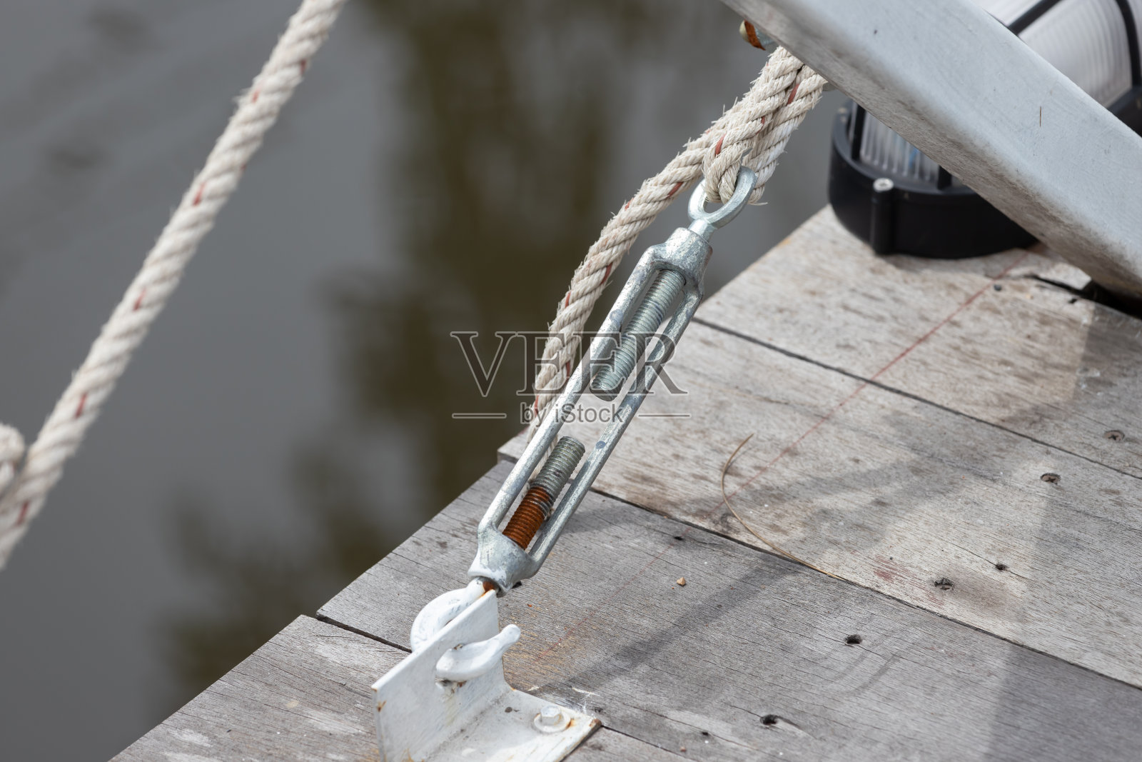 木桥用钢制螺丝扣和绳索。金属紧固件。照片摄影图片