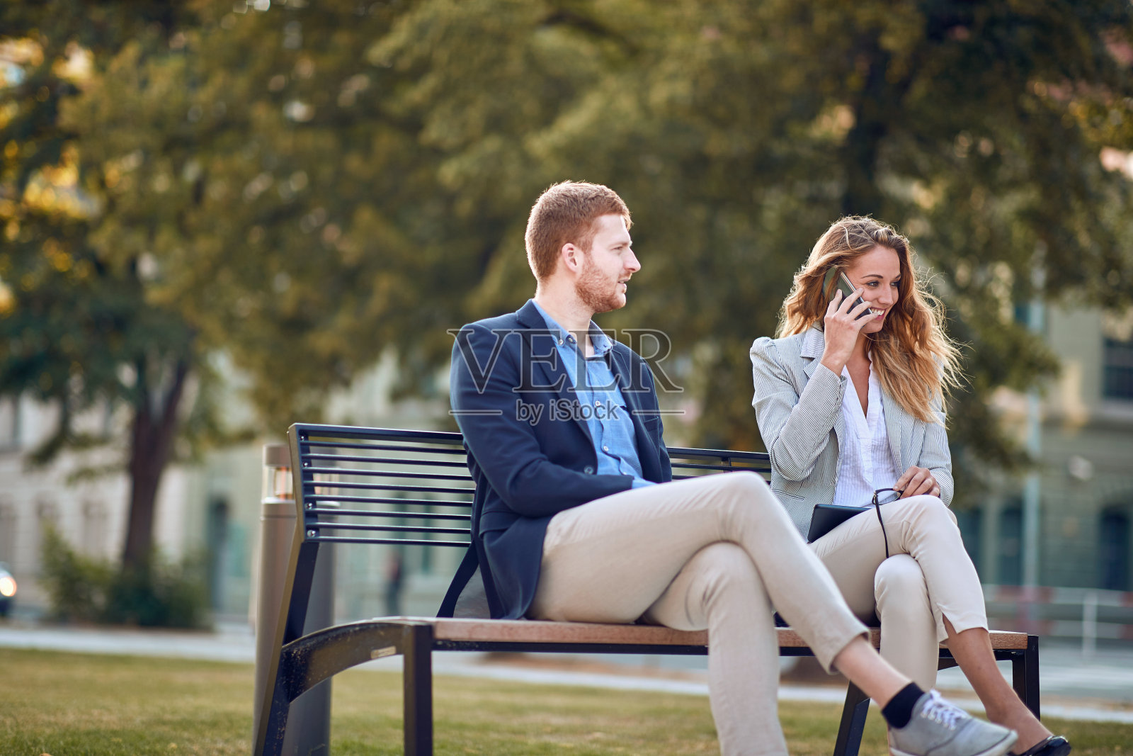 休息时坐在户外长椅上的商务人士照片摄影图片