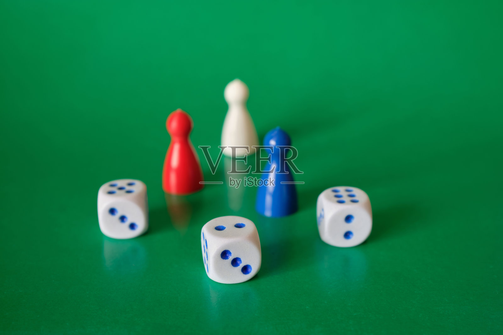 骰子和游戏块的不同颜色。在绿色的桌子上收集方块。照片摄影图片