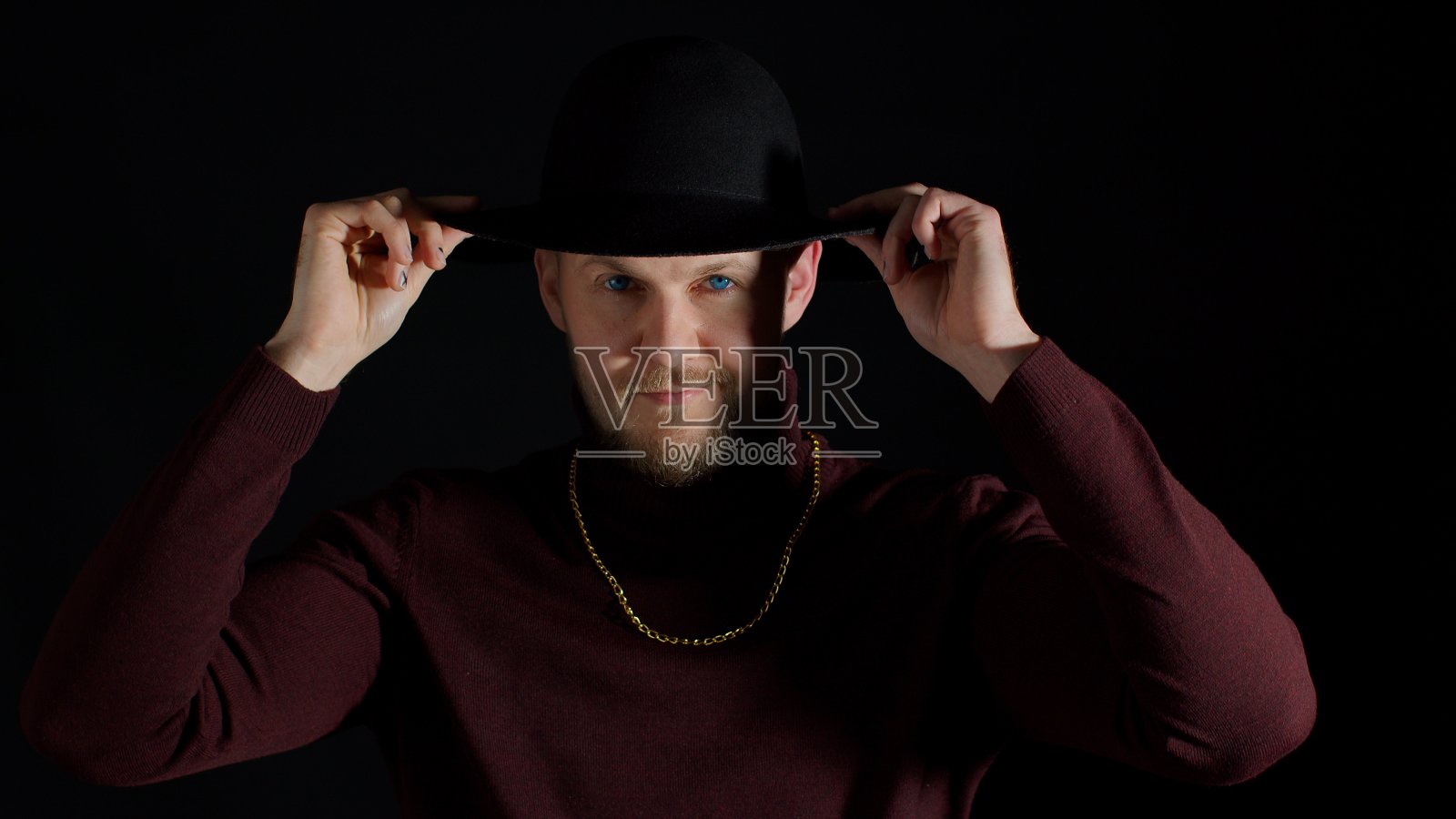 迷人的微笑年轻男子的肖像在时尚的衣服和帽子的黑色背景照片摄影图片